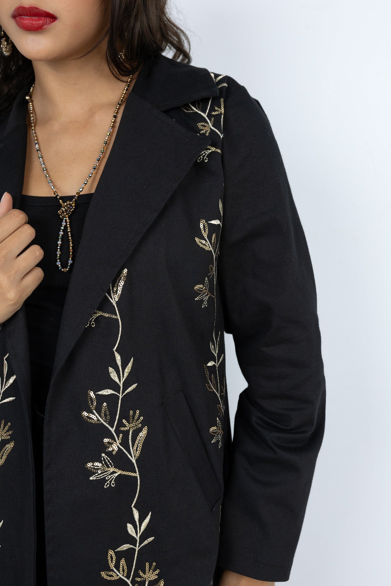 Black blazer with gold embroidery on a white background