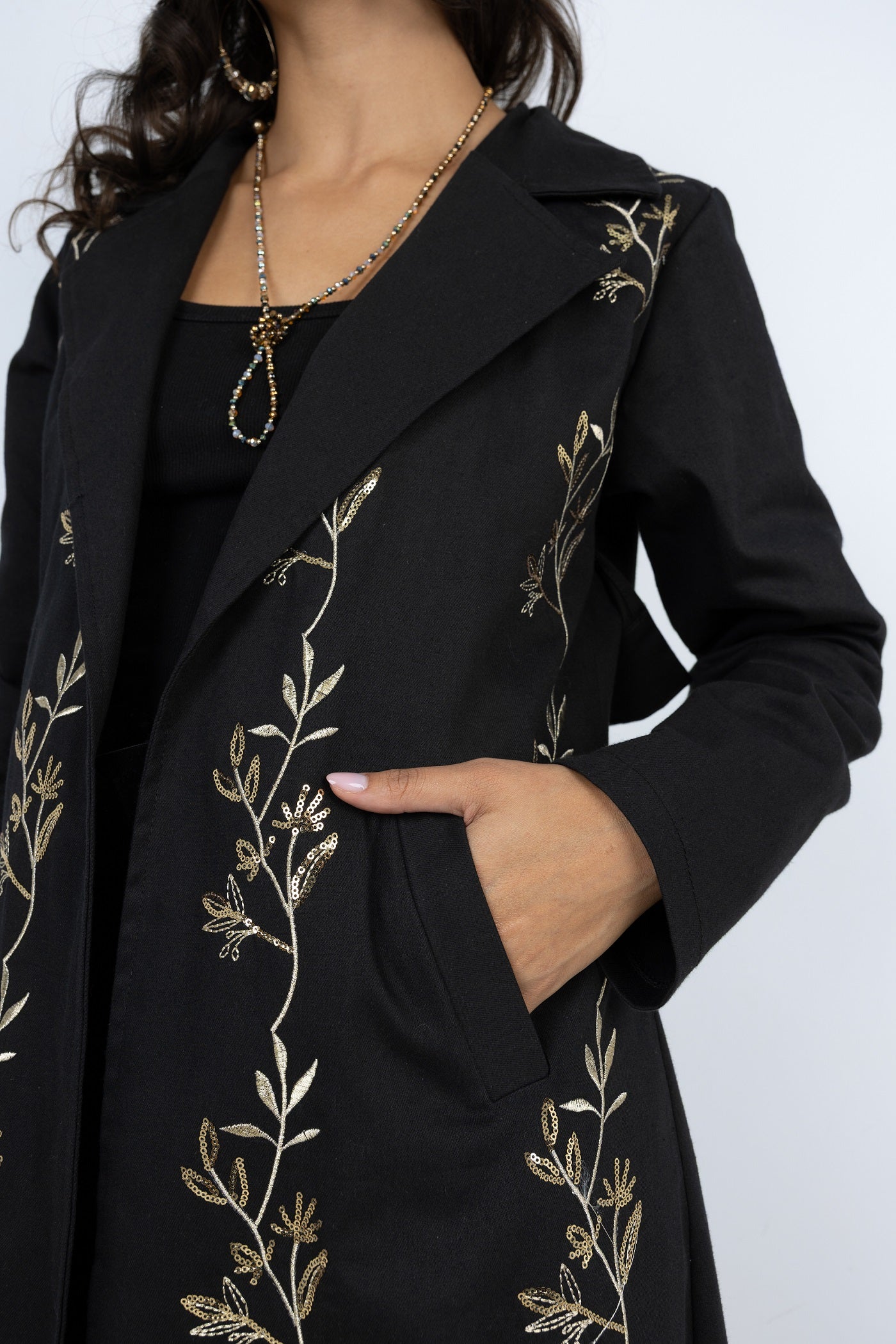 Black coat with gold embroidery on a white background