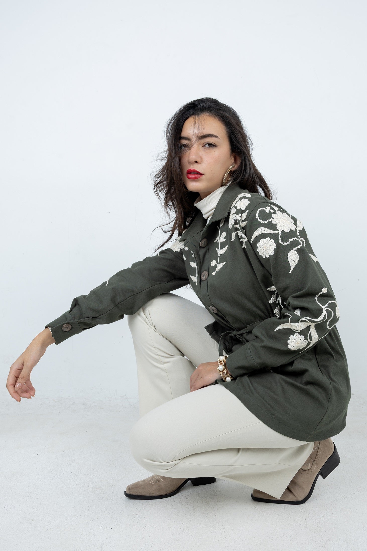 Woman wearing a green floral jacket on a white background