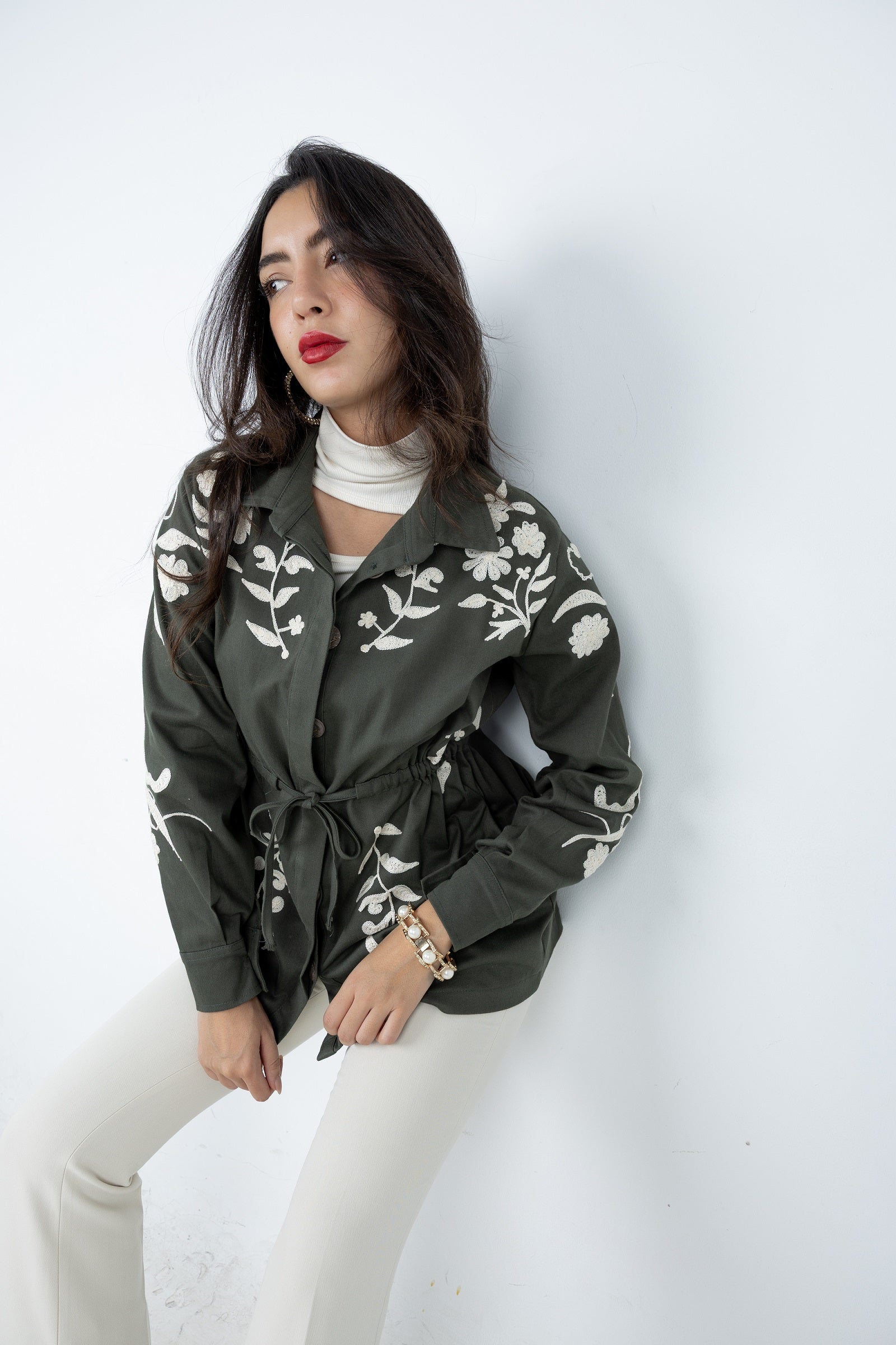 Woman wearing a green floral blouse against a white background