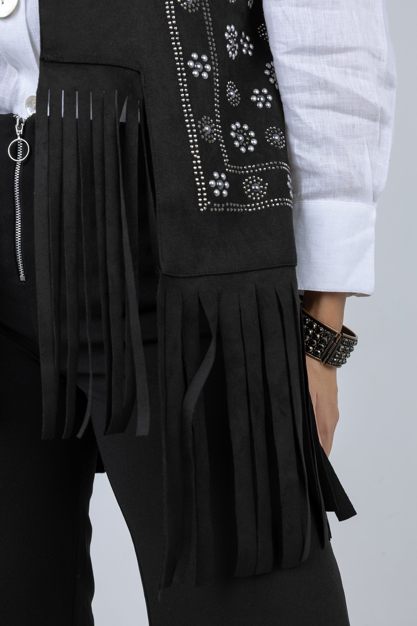 Black fringed jacket with white shirt on a plain background