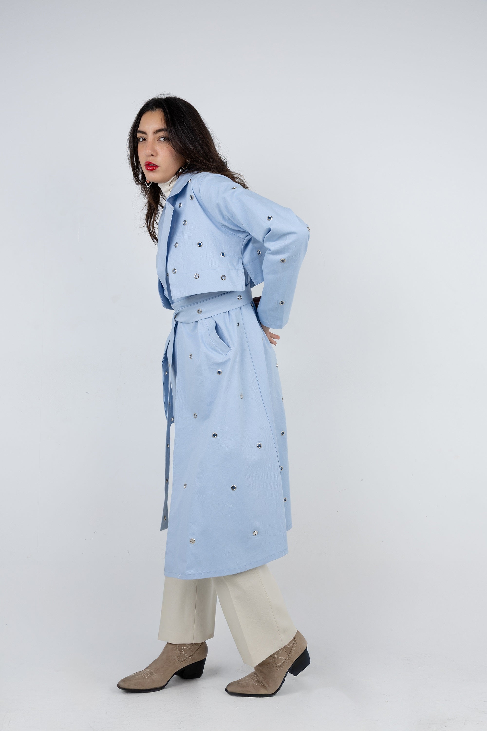 Woman wearing a light blue coat with a white background