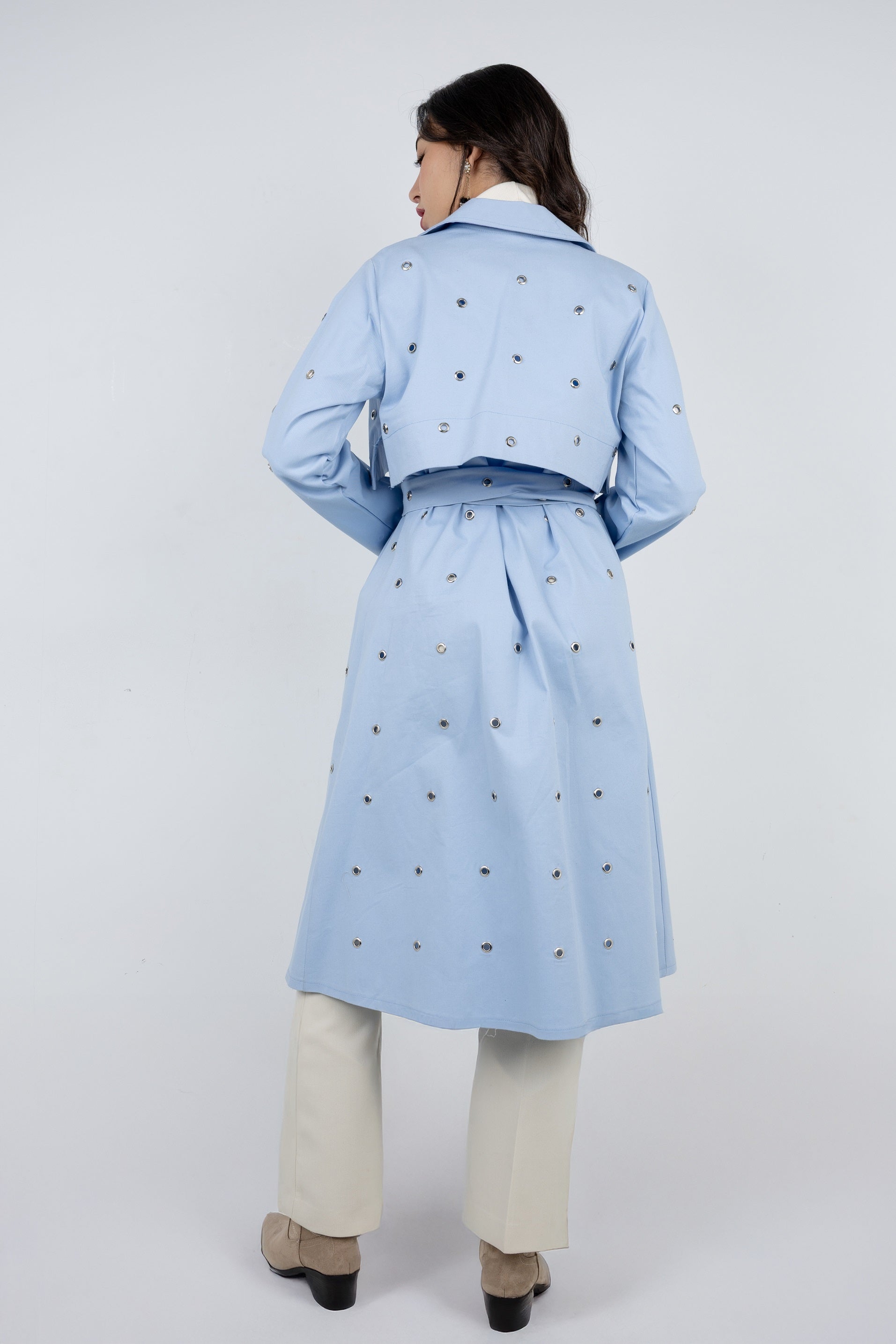 Person wearing a light blue coat with a white background