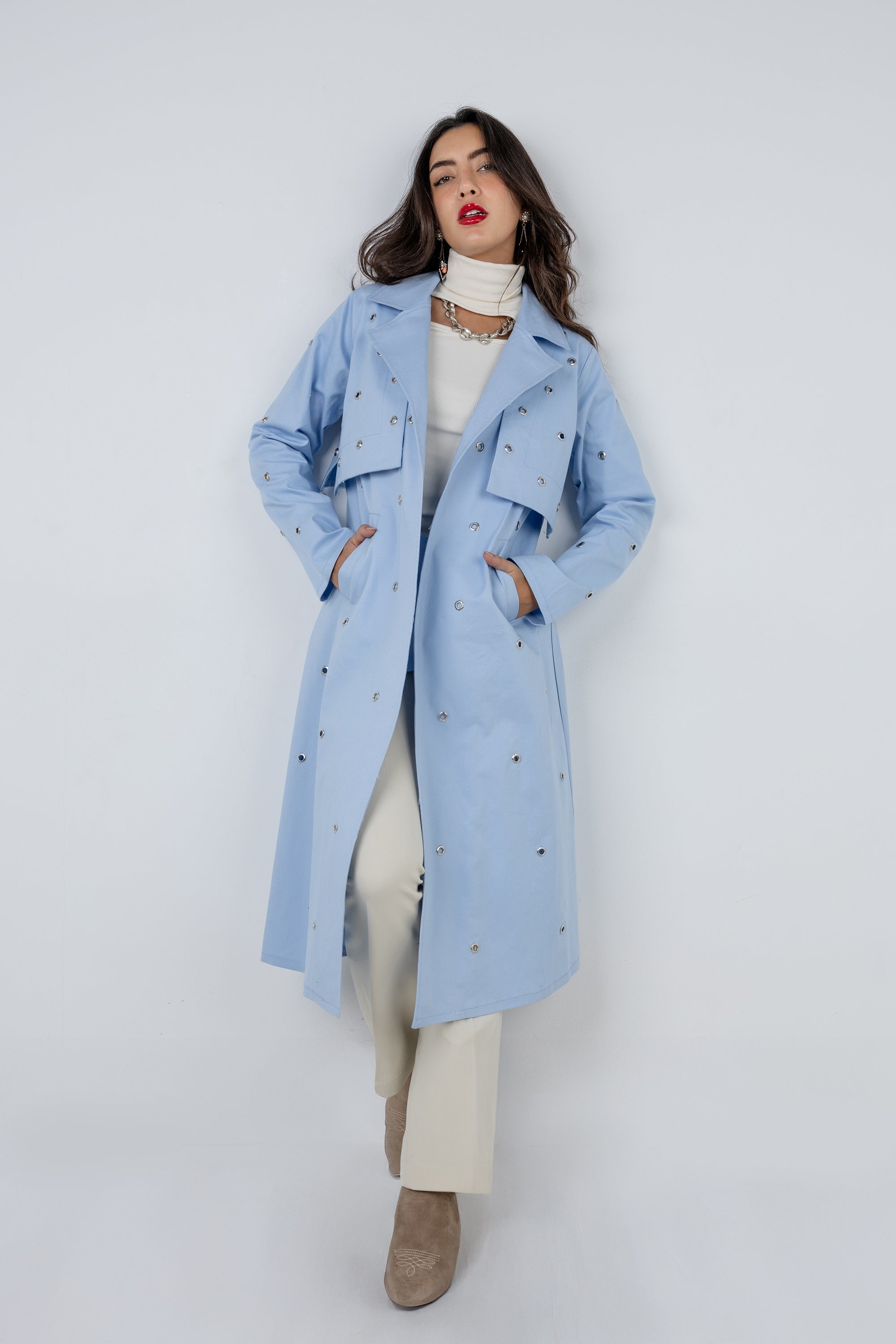 Woman wearing a light blue coat with a white background