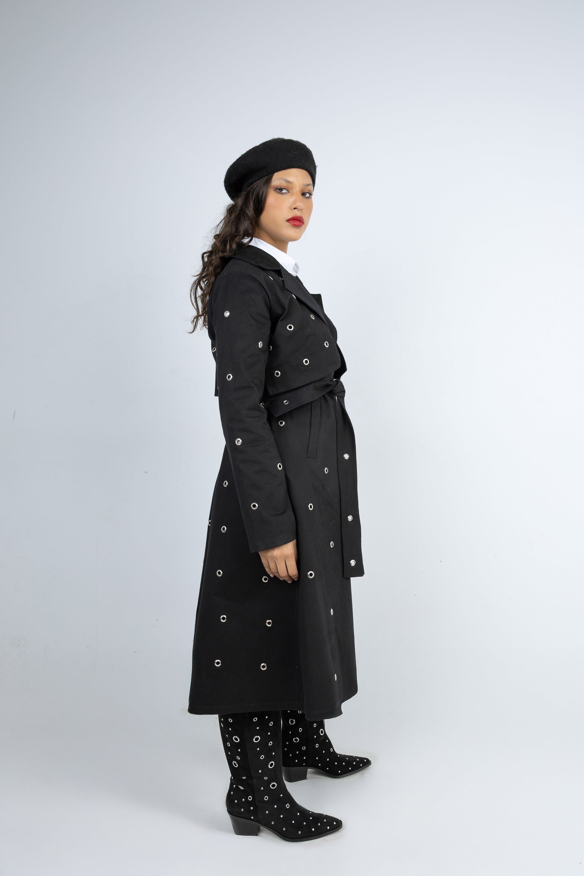 Woman wearing a black coat with white patterns on a white background