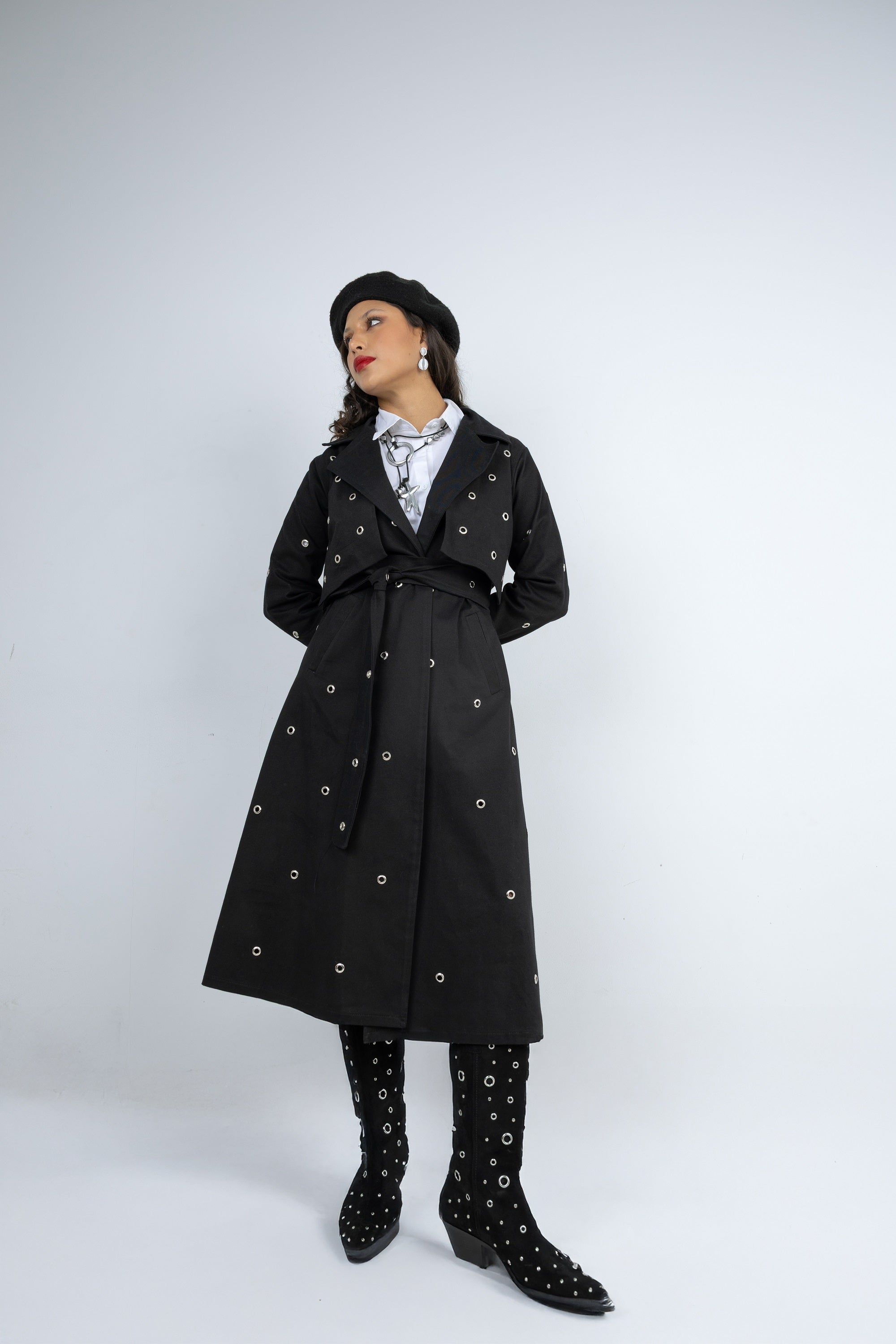 Person wearing a black coat with white patterns on a white background