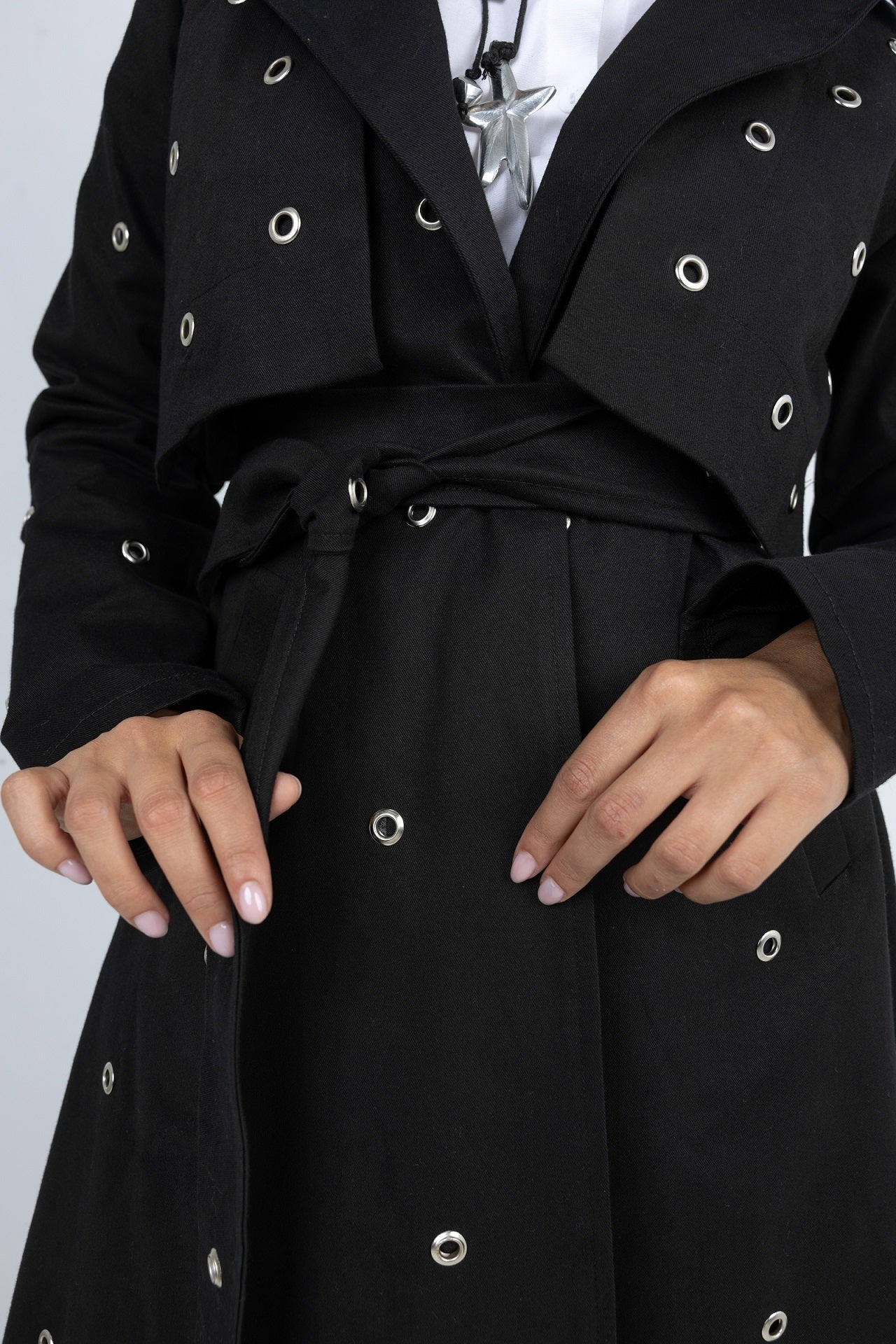 Black trench coat with decorative buttons on a plain background
