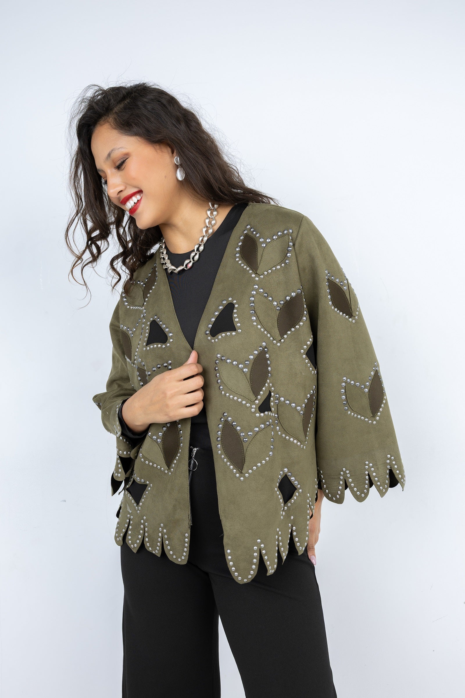 Woman wearing a green patterned cardigan against a white background