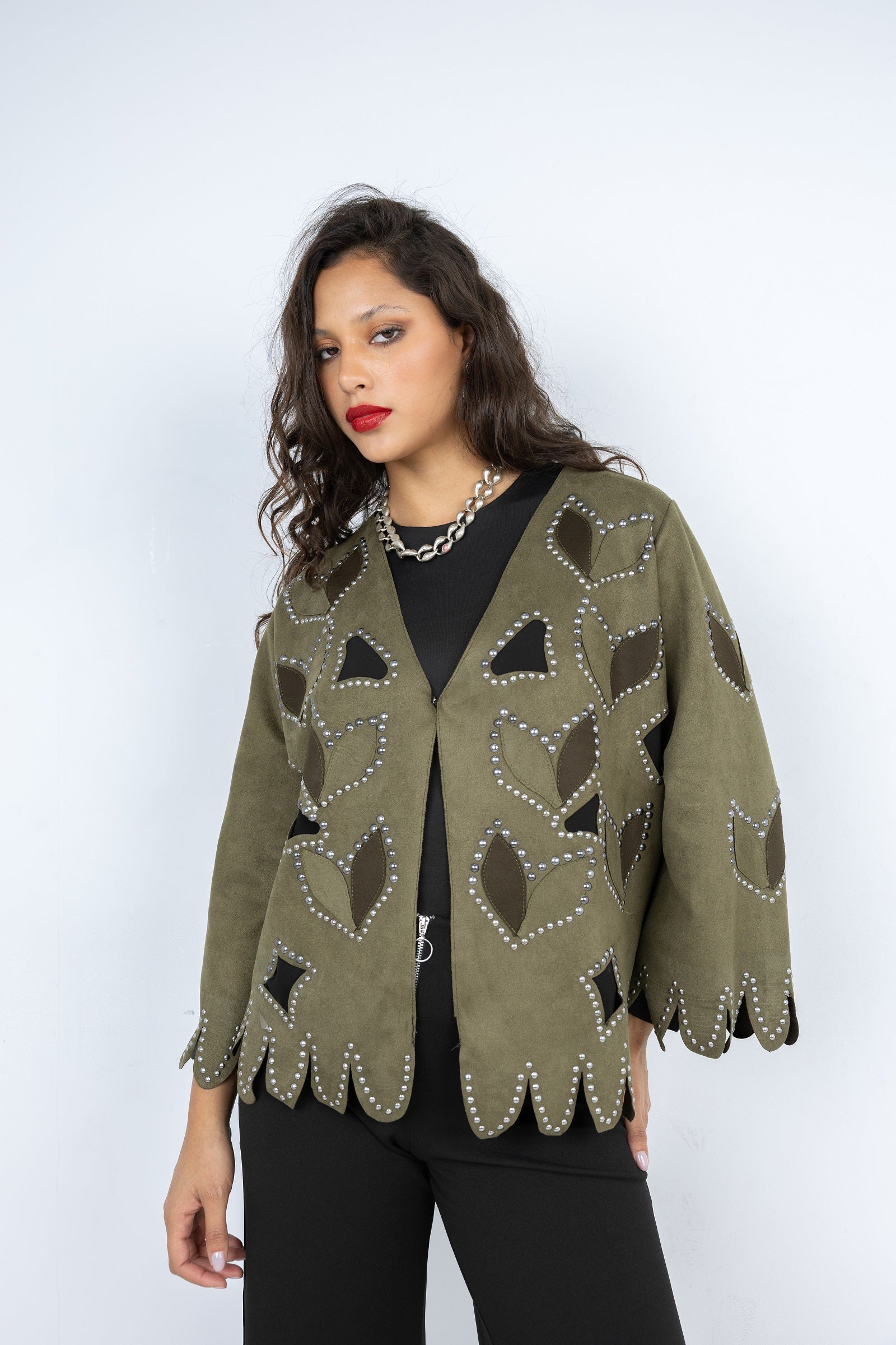 Woman wearing a green patterned jacket on a white background