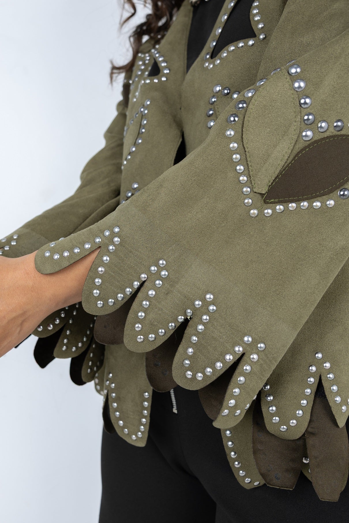 Green gloves with pearl embellishments on a white background