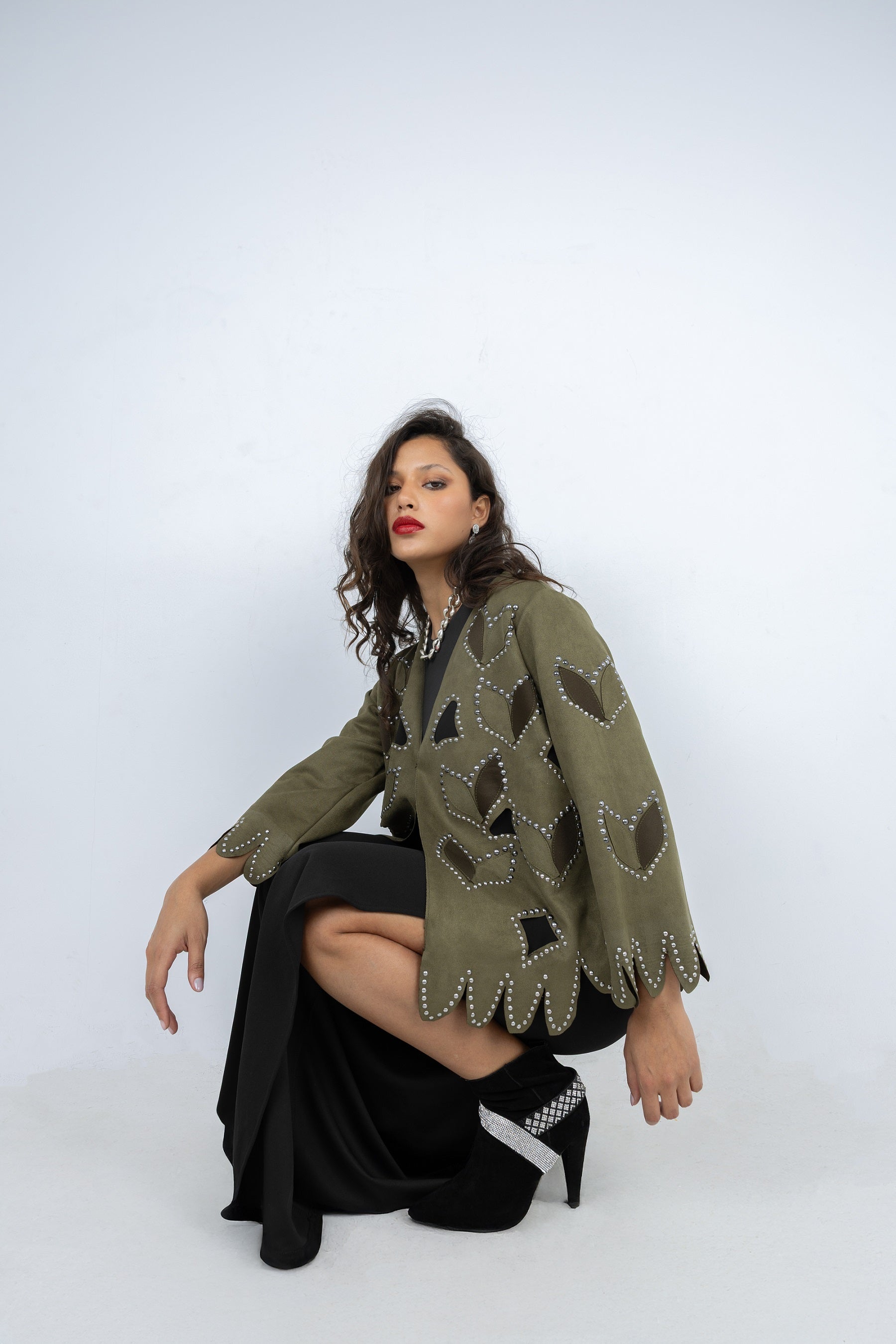 Woman wearing a green patterned cardigan on a white background