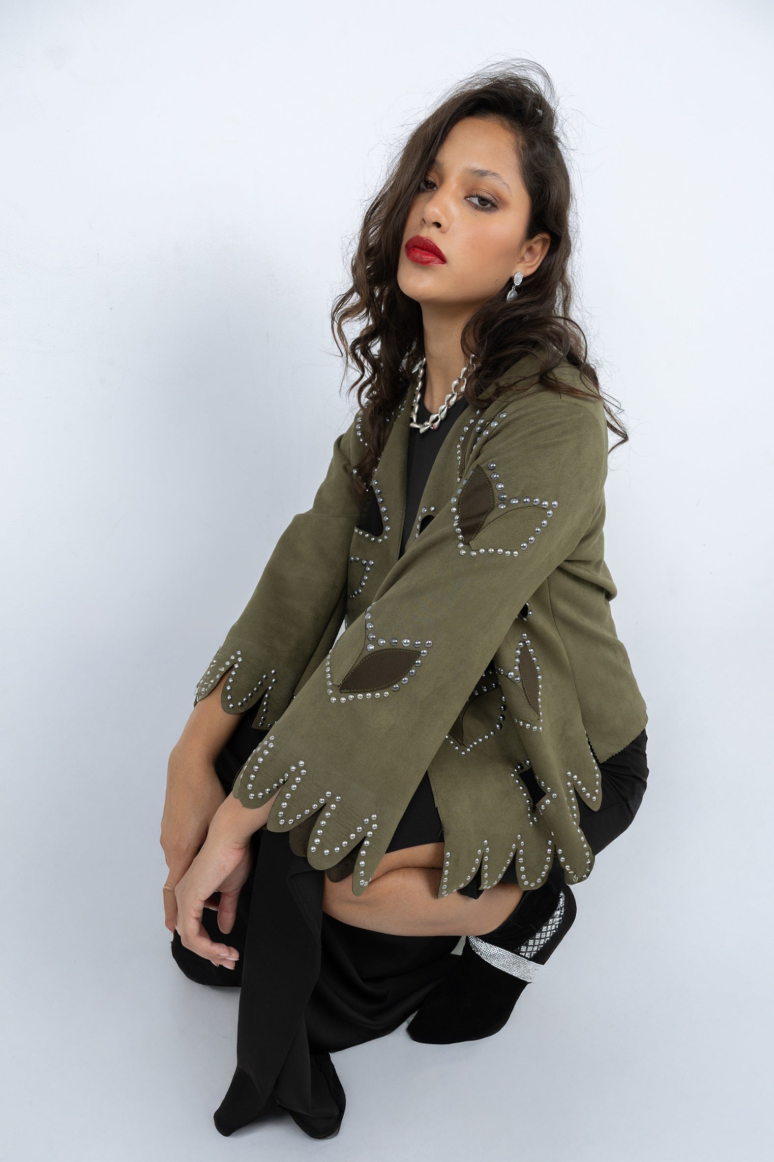 Woman wearing a green cardigan with decorative elements on a white background