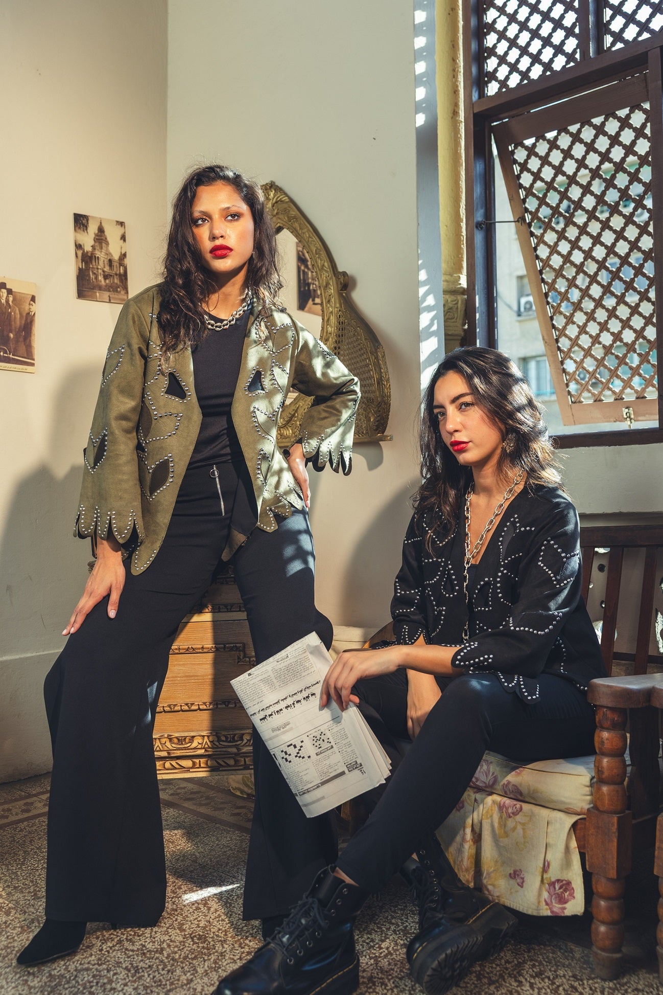 Two women sitting in a room with decorative elements and a window.