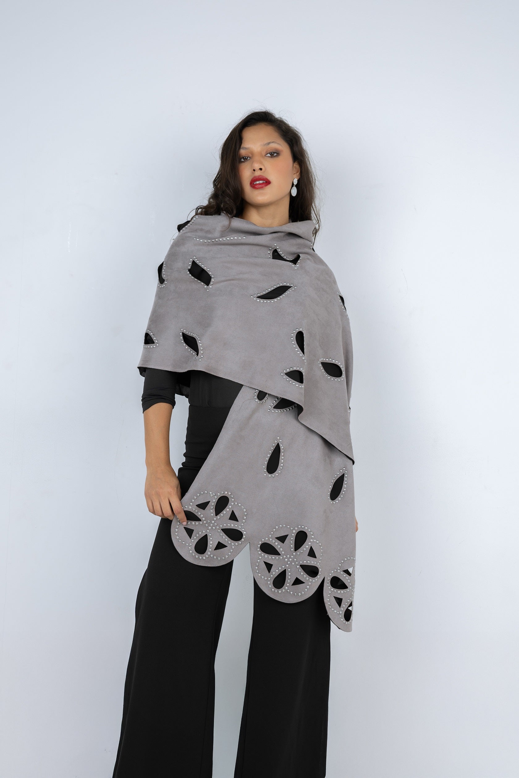 Woman wearing a gray scarf with black leaf patterns on a white background