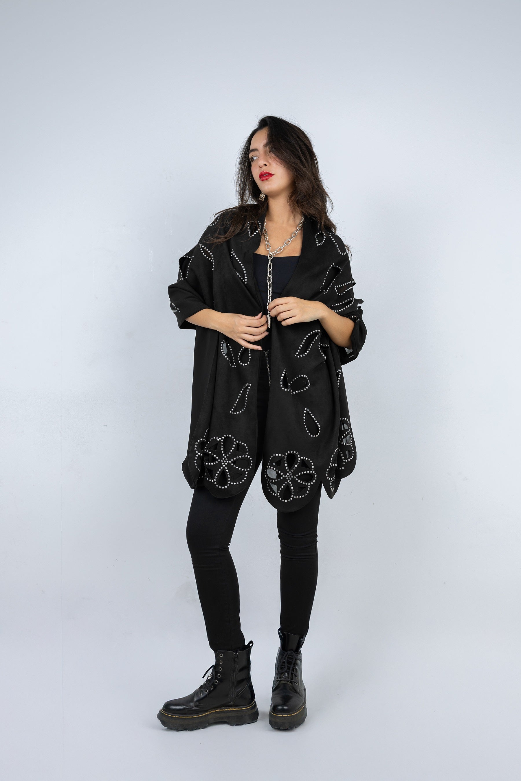 Woman wearing a black floral embroidered jacket on a white background