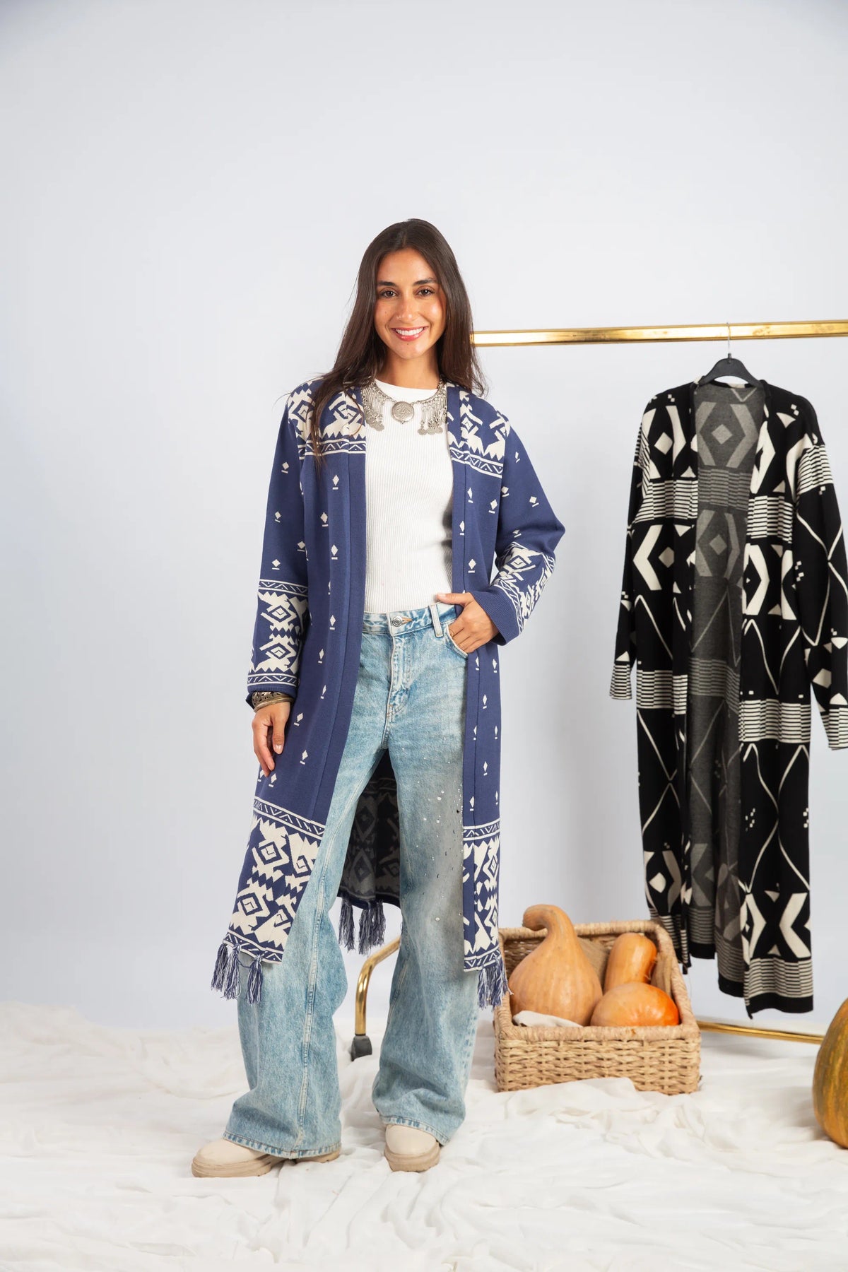 Woman wearing a blue patterned cardigan with a white background