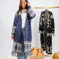 Woman wearing a blue patterned dress with a matching coat, standing next to a rack of similar clothing.