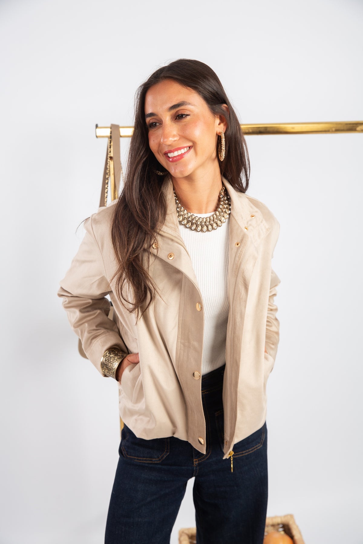 Woman wearing a beige jacket with a white background