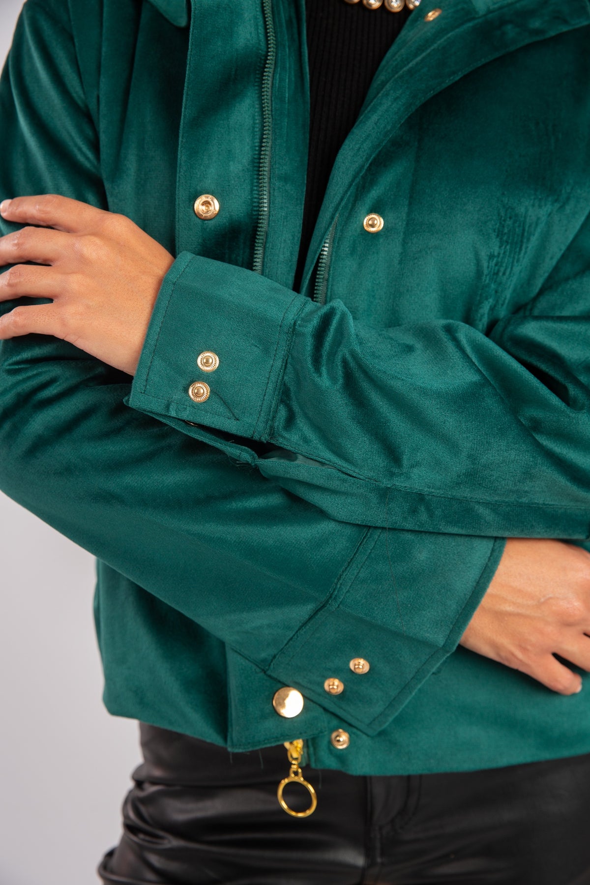 Green jacket with gold buttons on a plain background