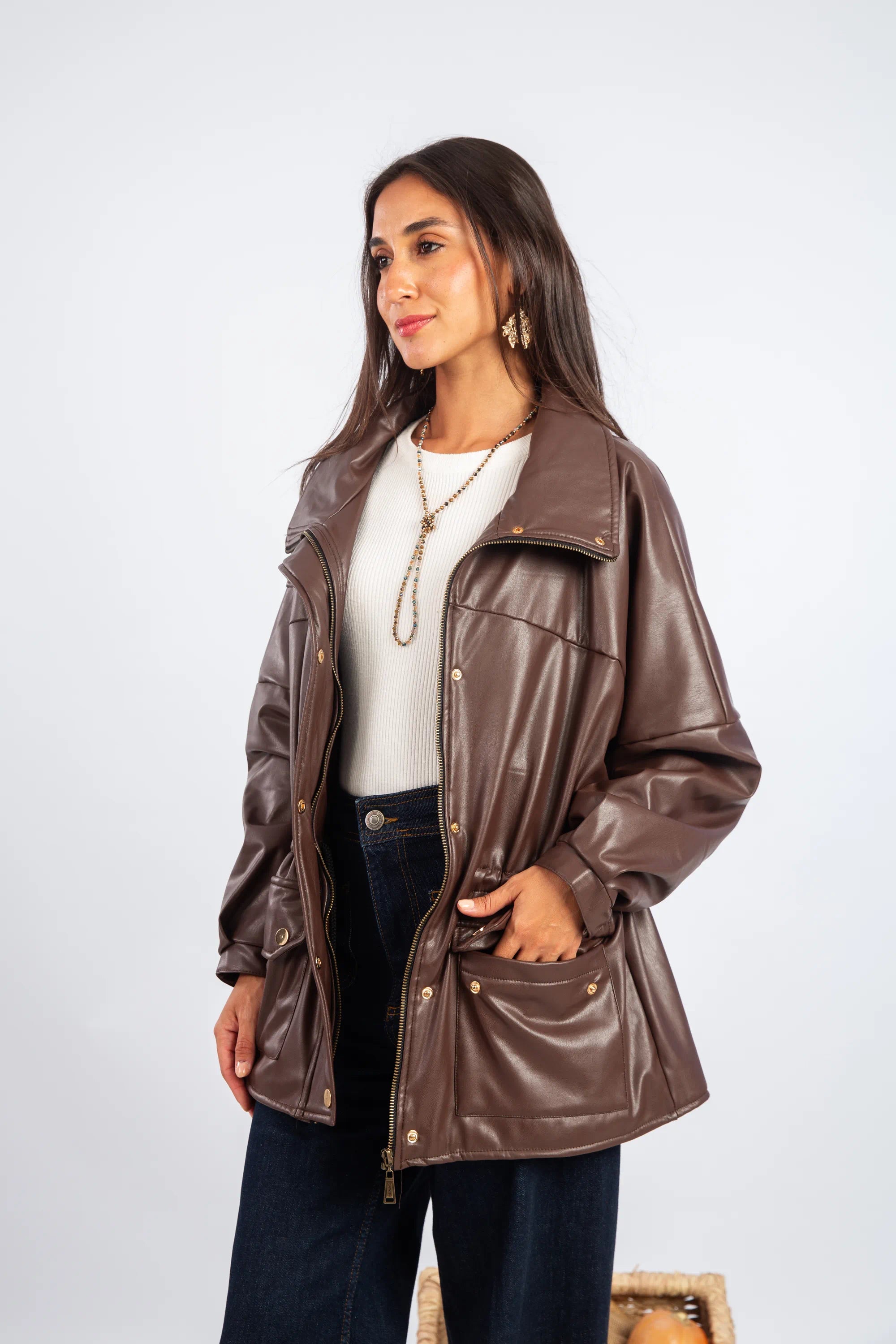 Woman wearing a brown leather jacket on a white background