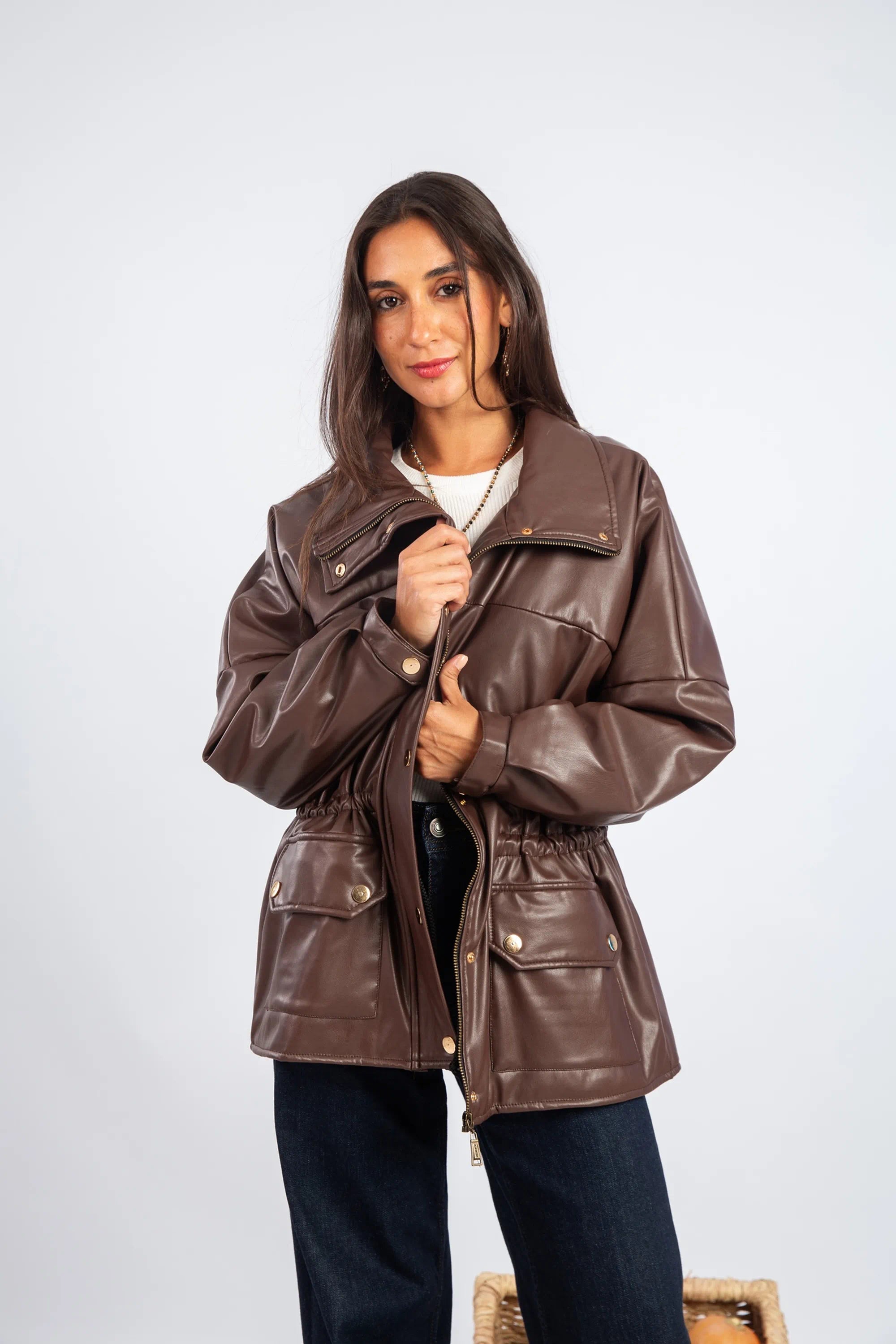 Woman wearing a brown leather jacket on a white background