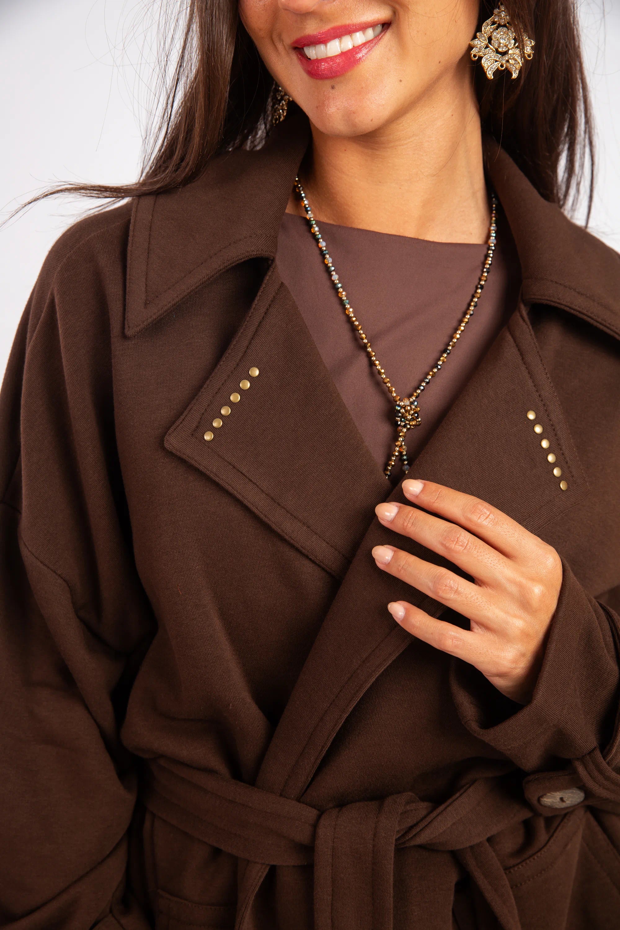 Woman wearing a brown coat with a white background