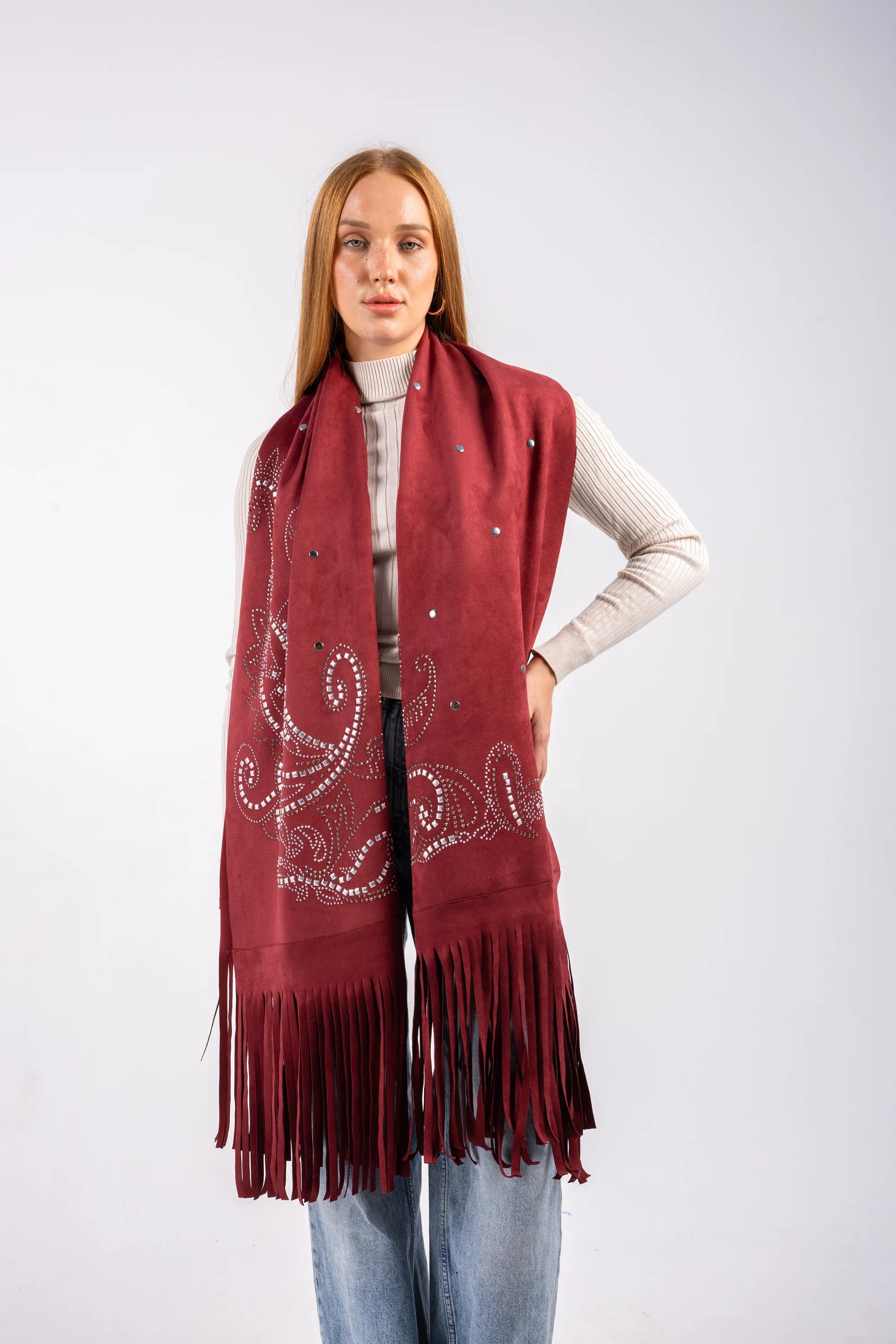 Woman wearing a burgundy scarf with decorative patterns and fringes on a white background
