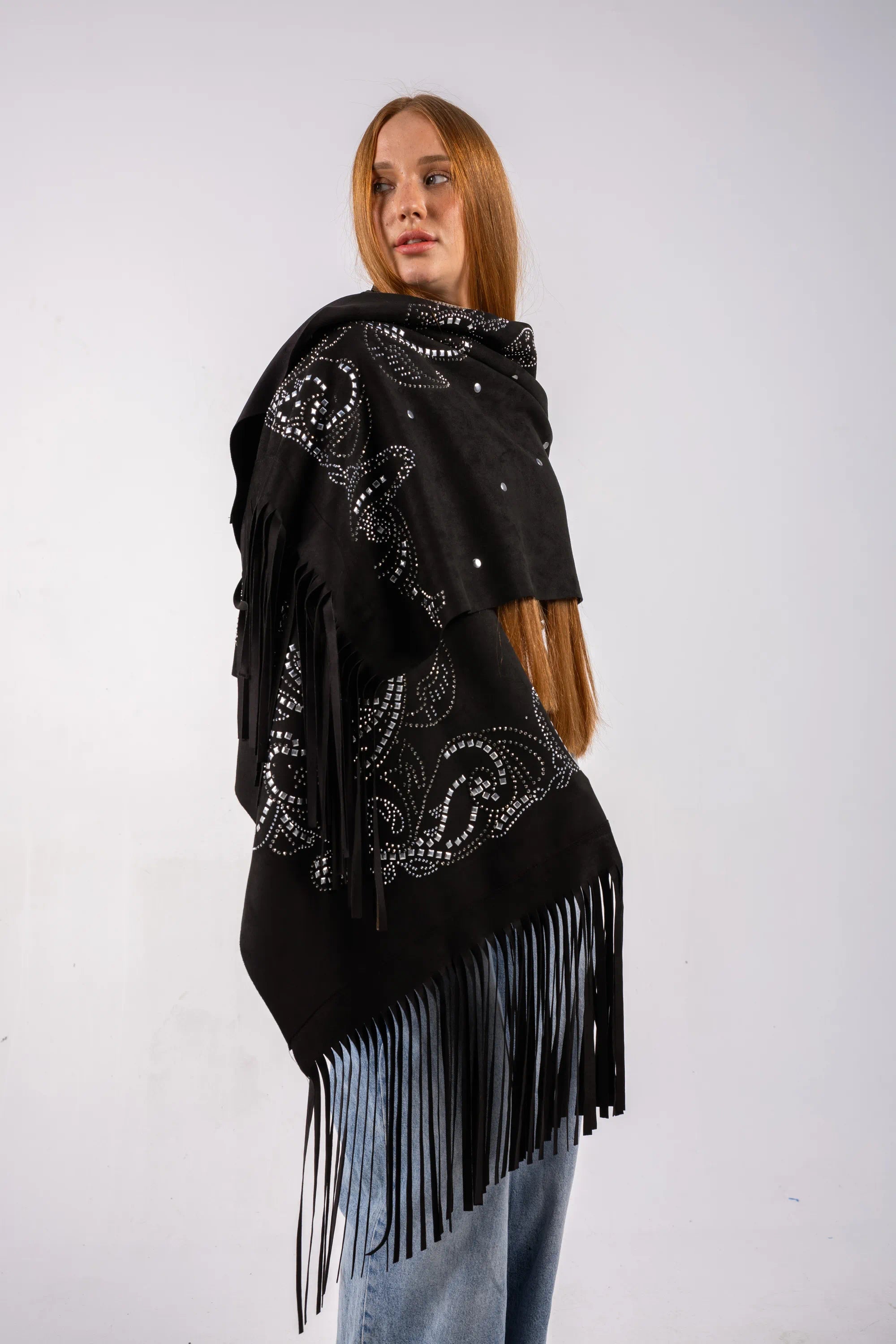 Woman wearing a black shawl with fringe and bead details on a white background