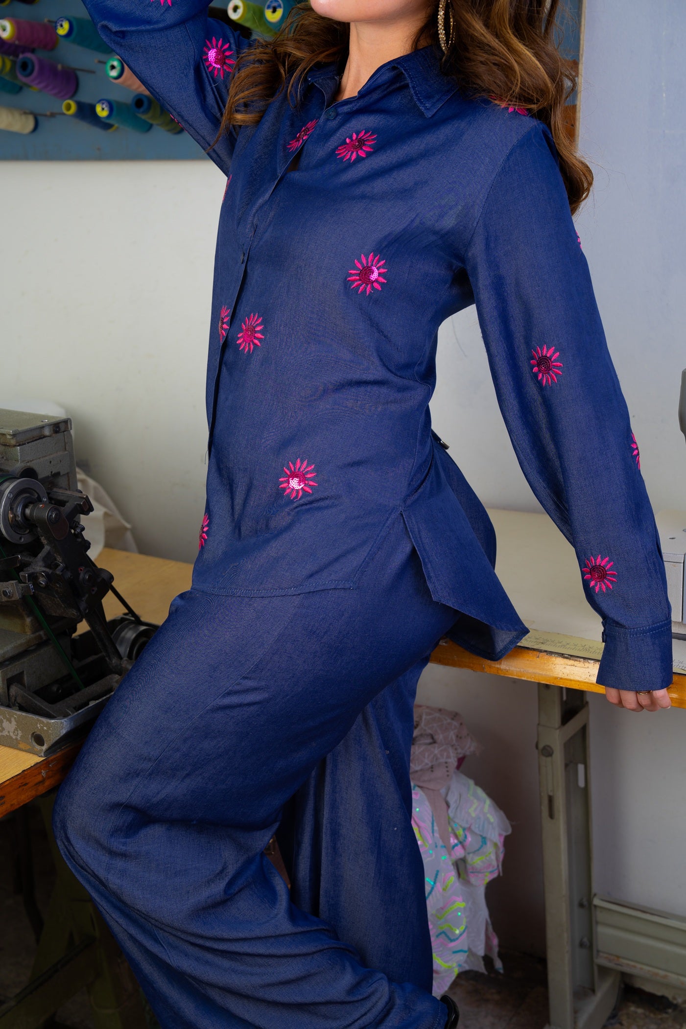 Person wearing a blue outfit with pink floral patterns in a workshop setting