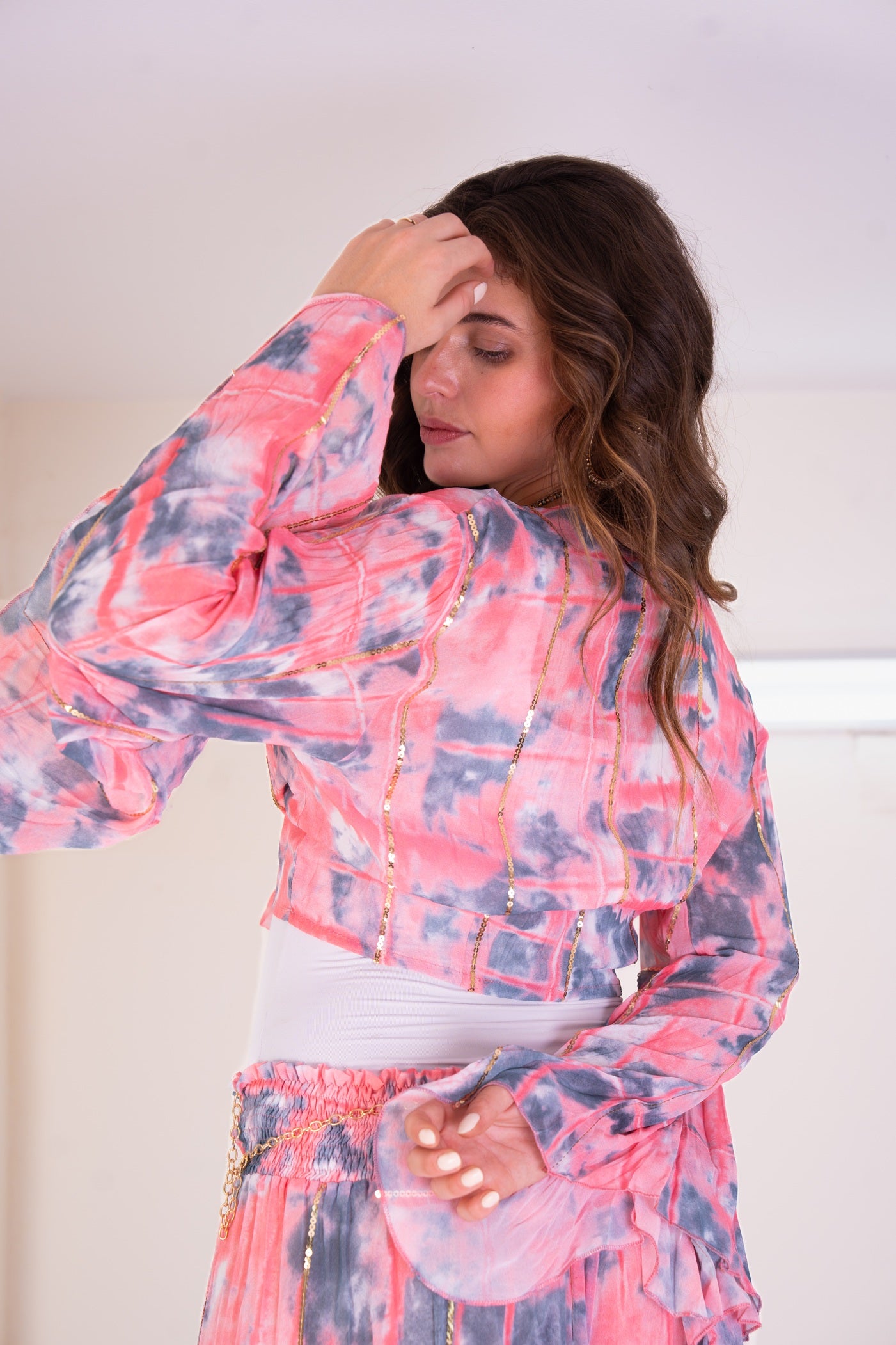 Woman wearing a pink and blue tie-dye outfit indoors.
