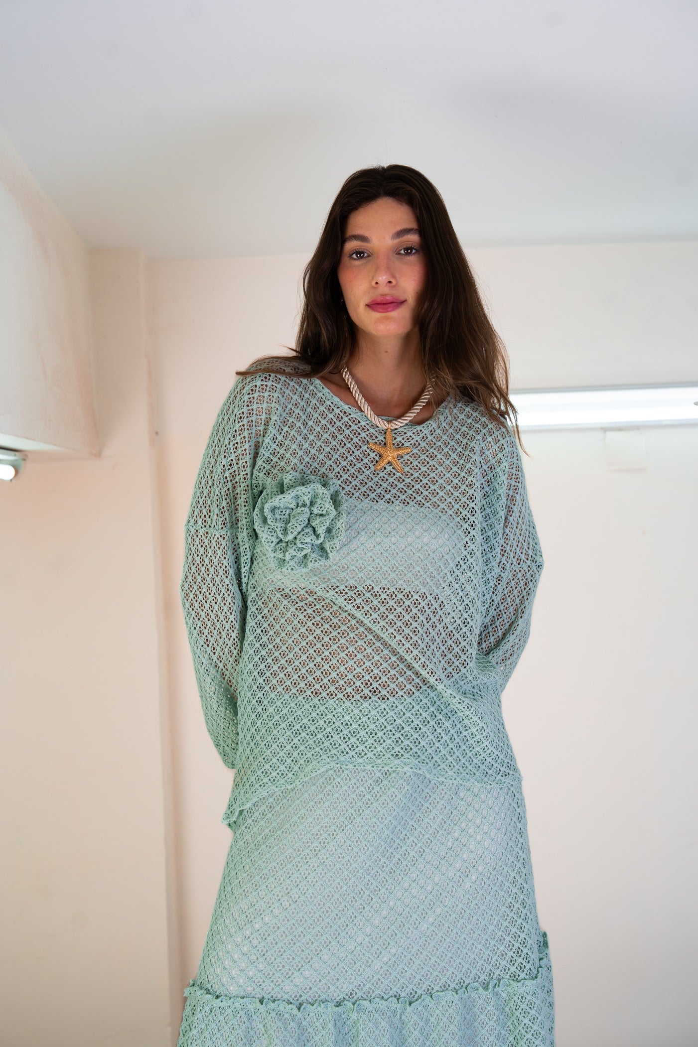 Woman wearing a light blue dress with a floral design in a room.