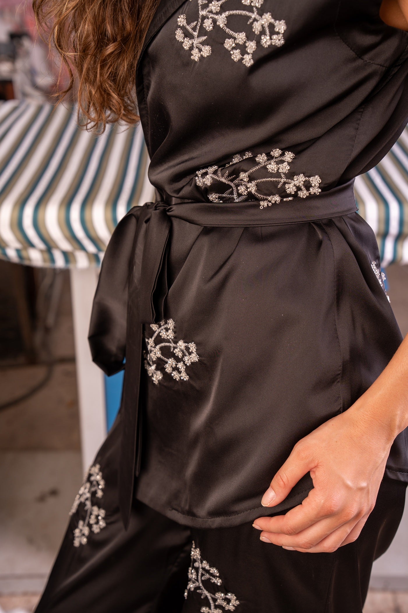 Black satin robe with floral embroidery on a blurred background