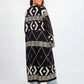 Woman wearing a long black and white patterned dress on a white background