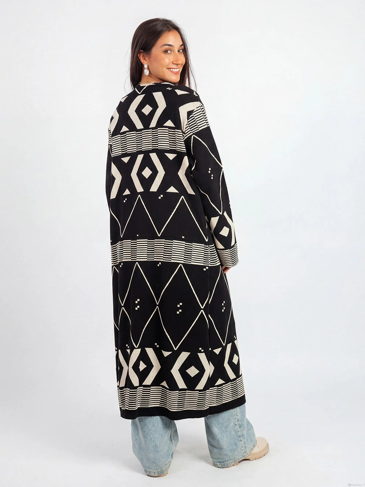 Woman wearing a long black and white patterned dress on a white background