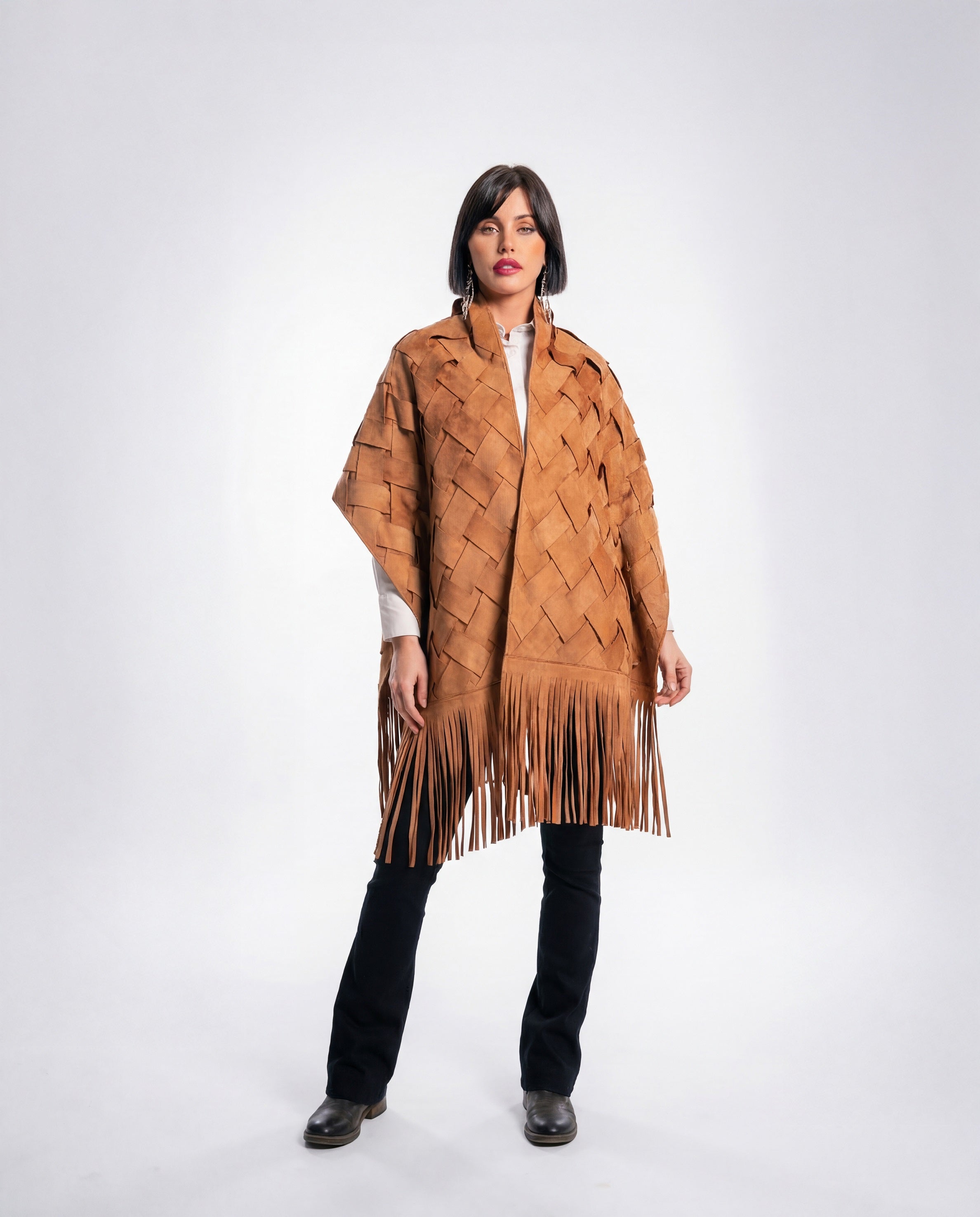 Woman wearing a brown woven poncho with fringes on a white background