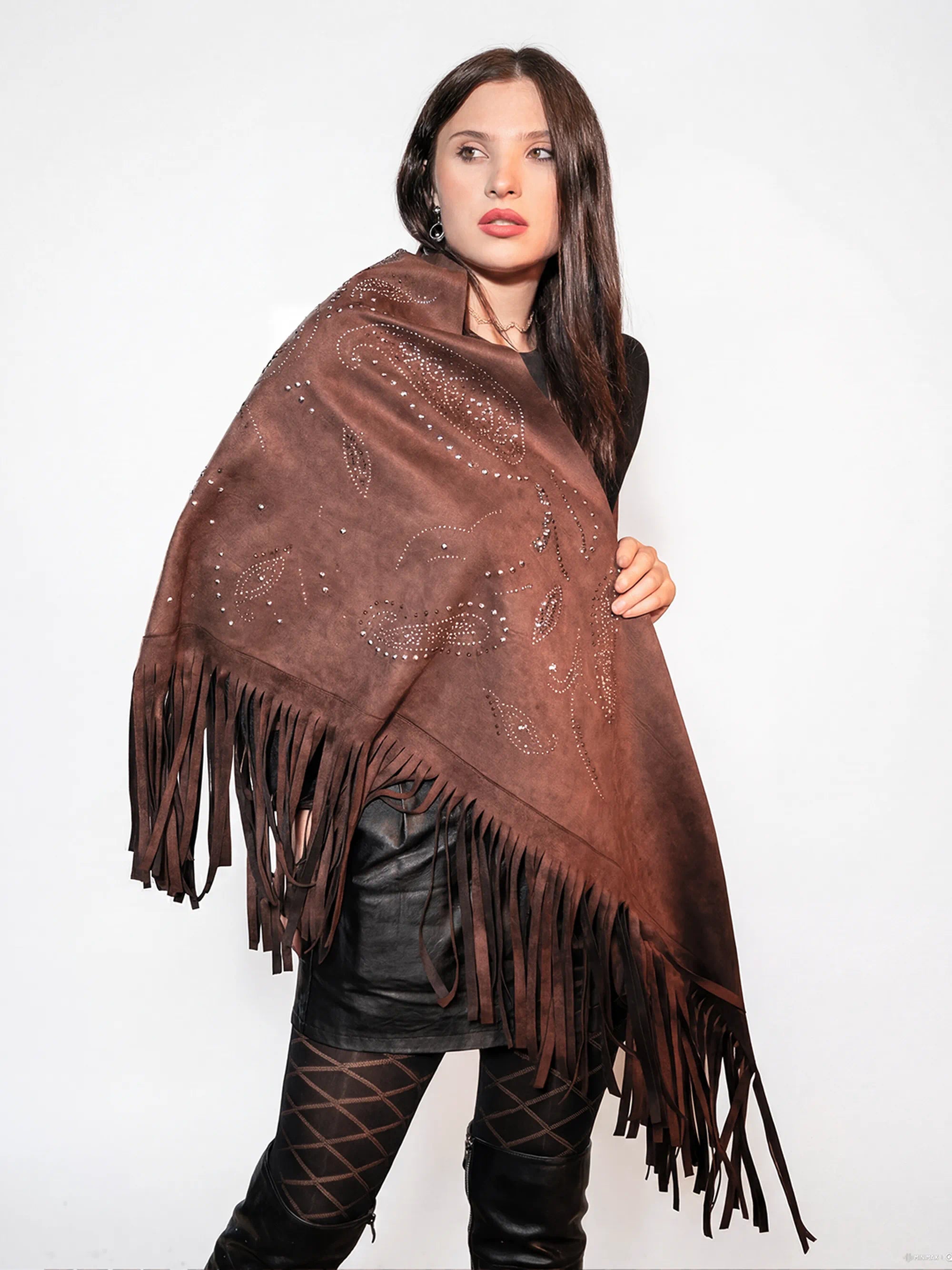 Woman wearing a brown fringed poncho against a white background