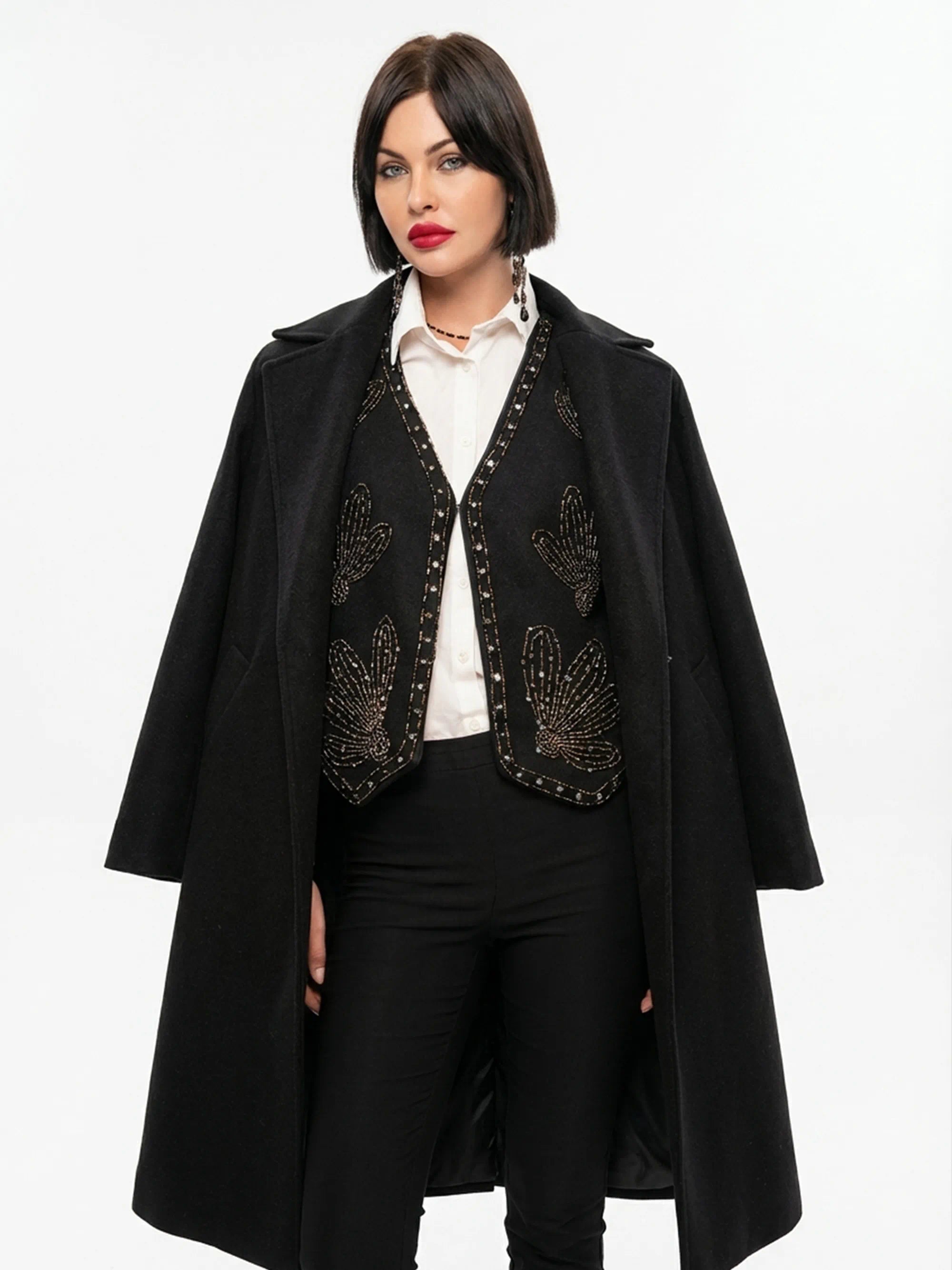 Woman wearing a black coat with decorative elements on a white background