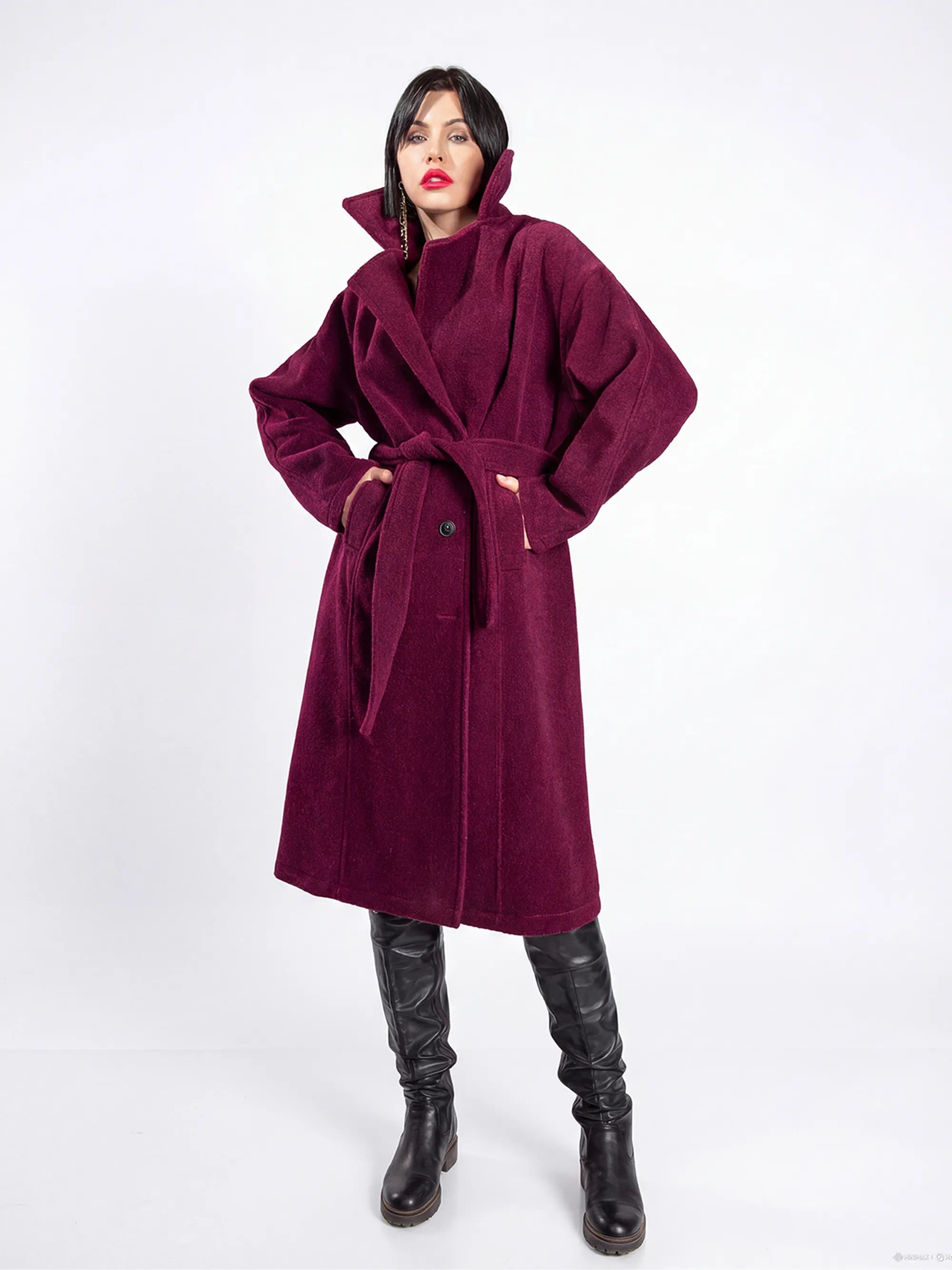 Woman wearing a long purple coat on a white background