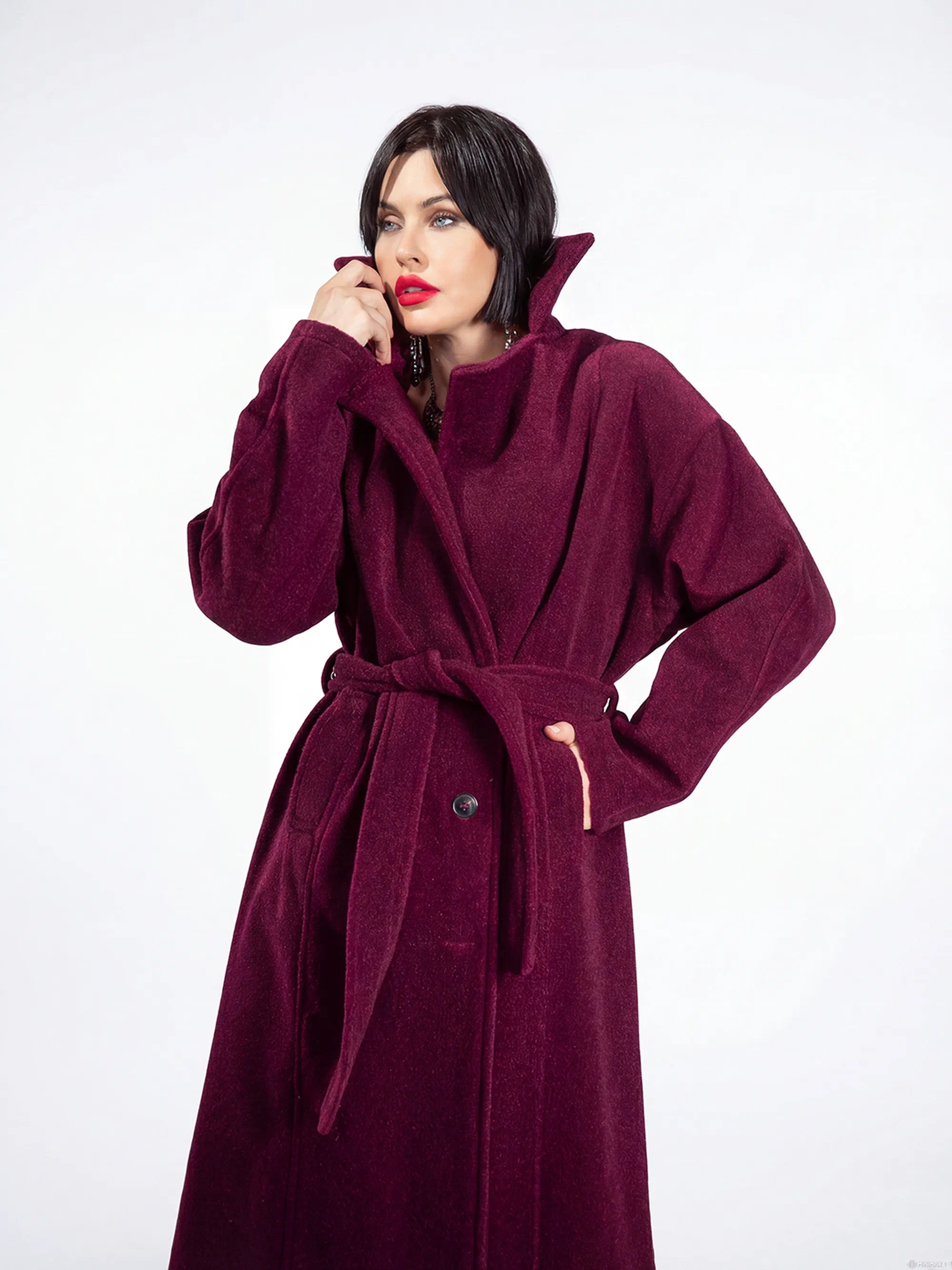Woman wearing a burgundy coat on a white background