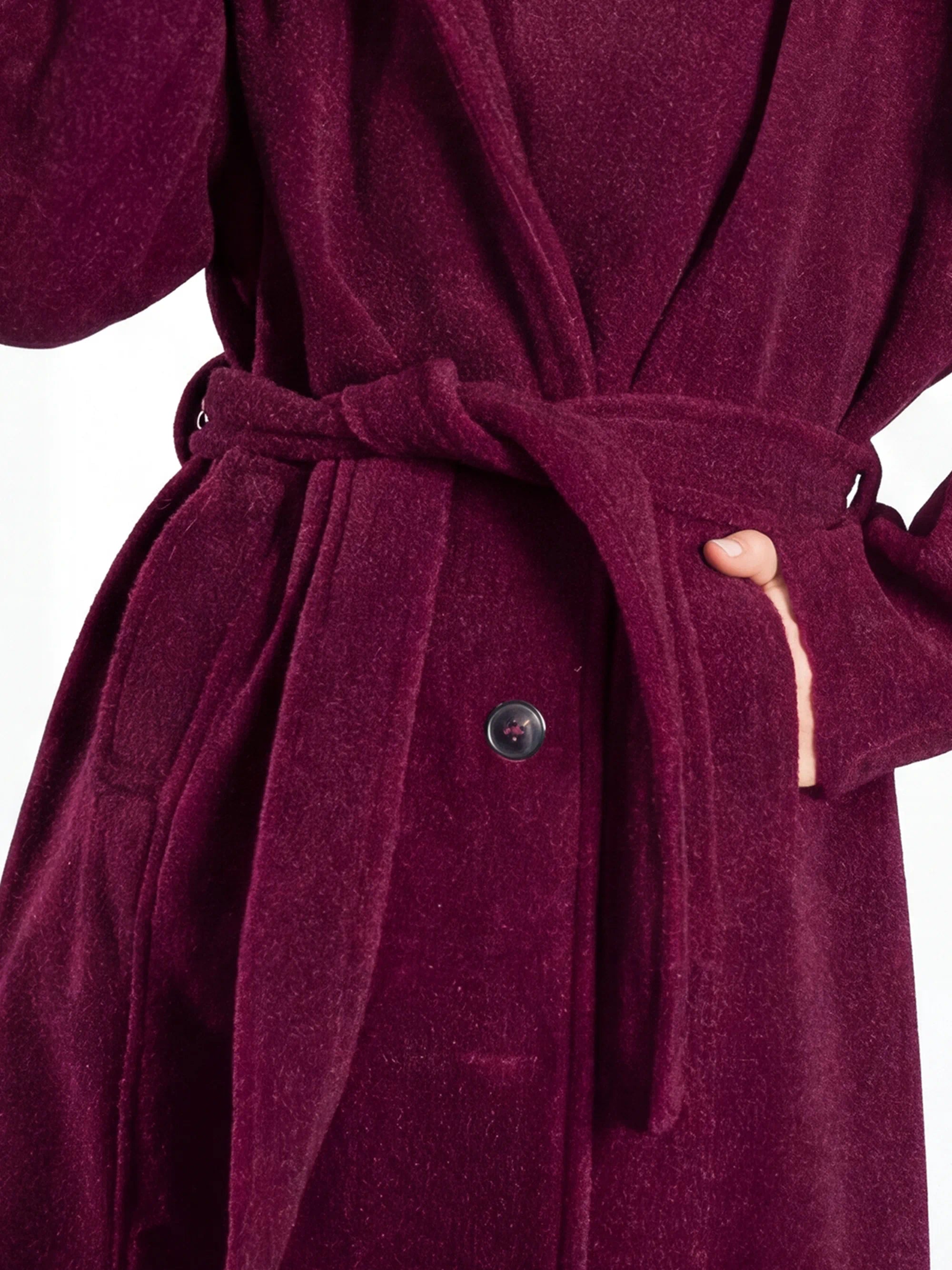 Close-up of a burgundy robe with a belt and button on a white background