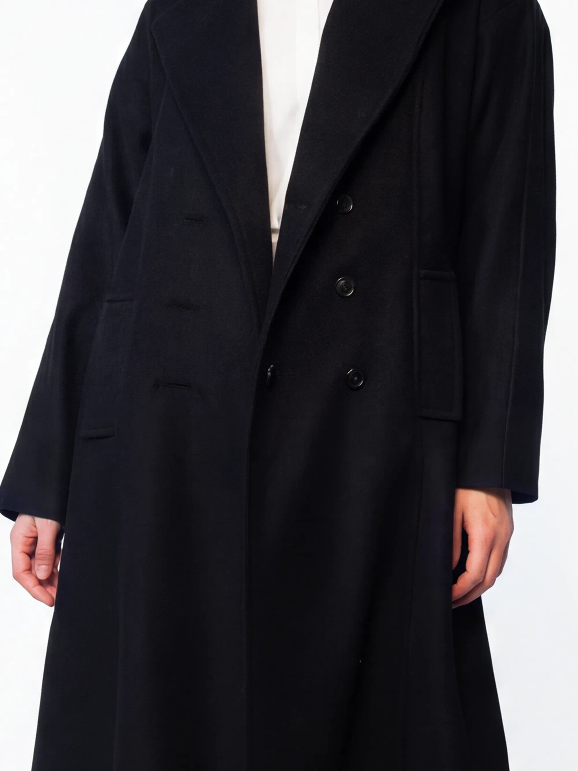 Black coat worn by a person on a white background