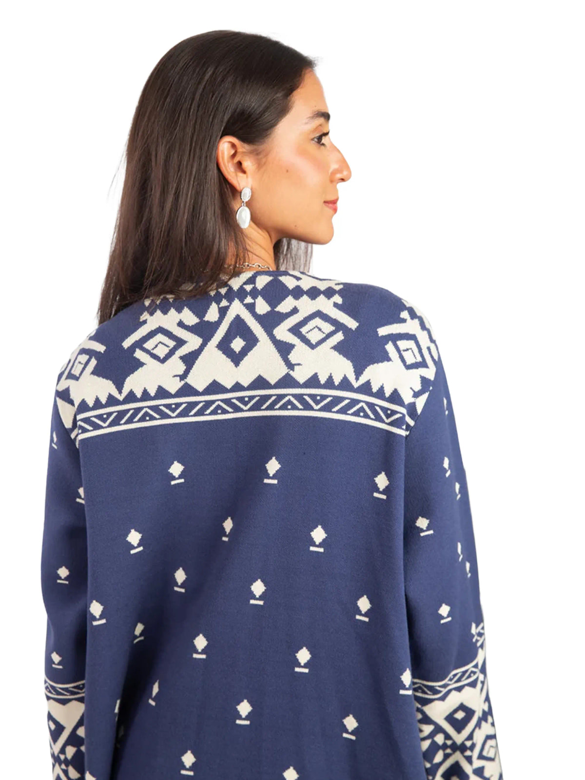 Woman wearing a navy blue sweater with white geometric patterns on a white background