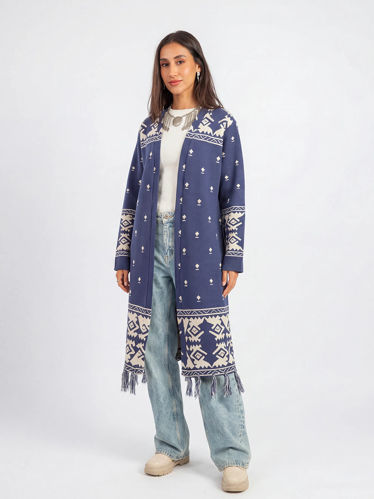 Woman wearing a blue patterned cardigan on a white background