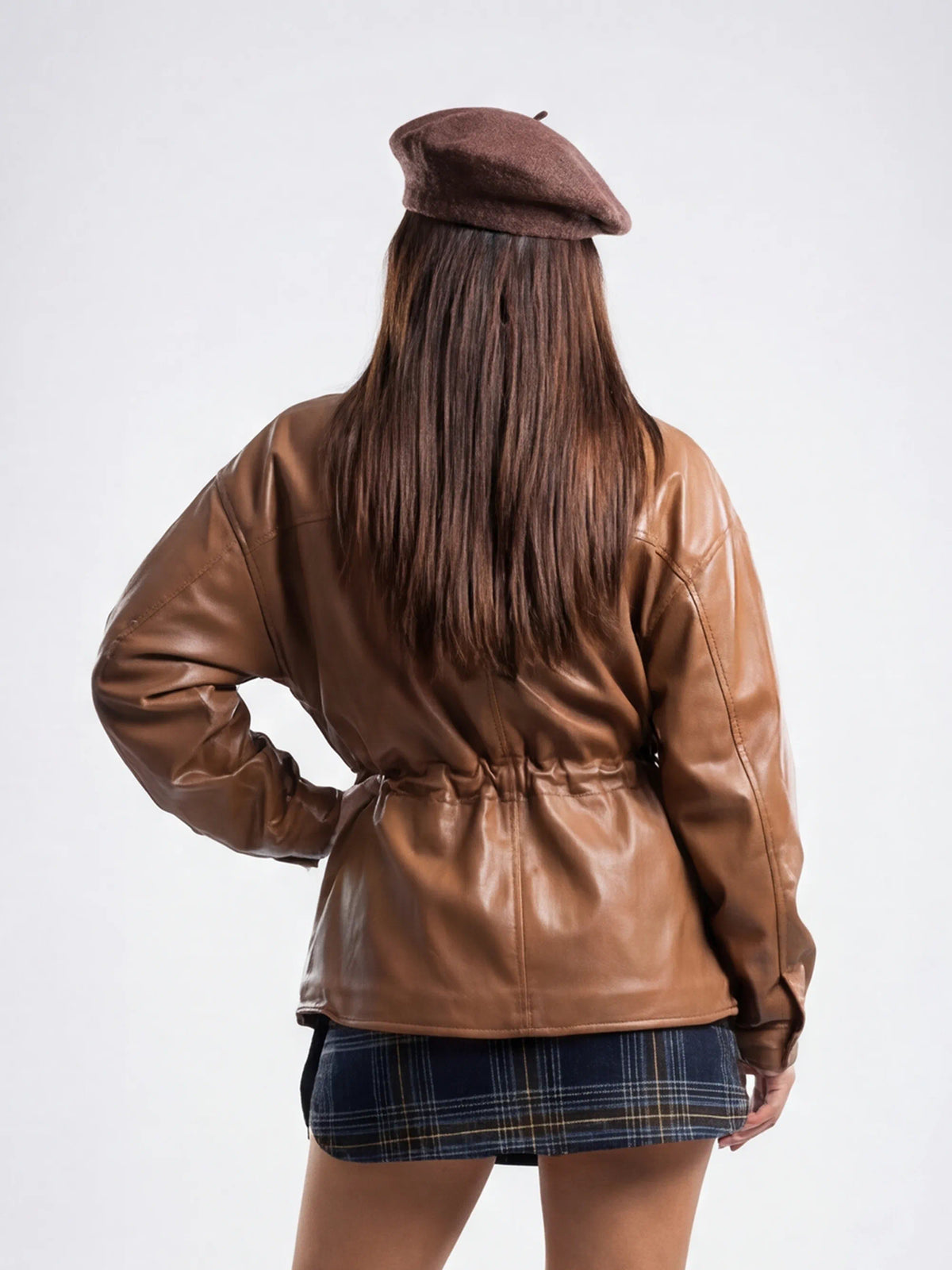 Person wearing a brown leather jacket and beret from behind on a white background