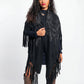 Woman wearing a black fringe poncho on a white background