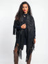 Woman wearing a black fringe poncho on a white background