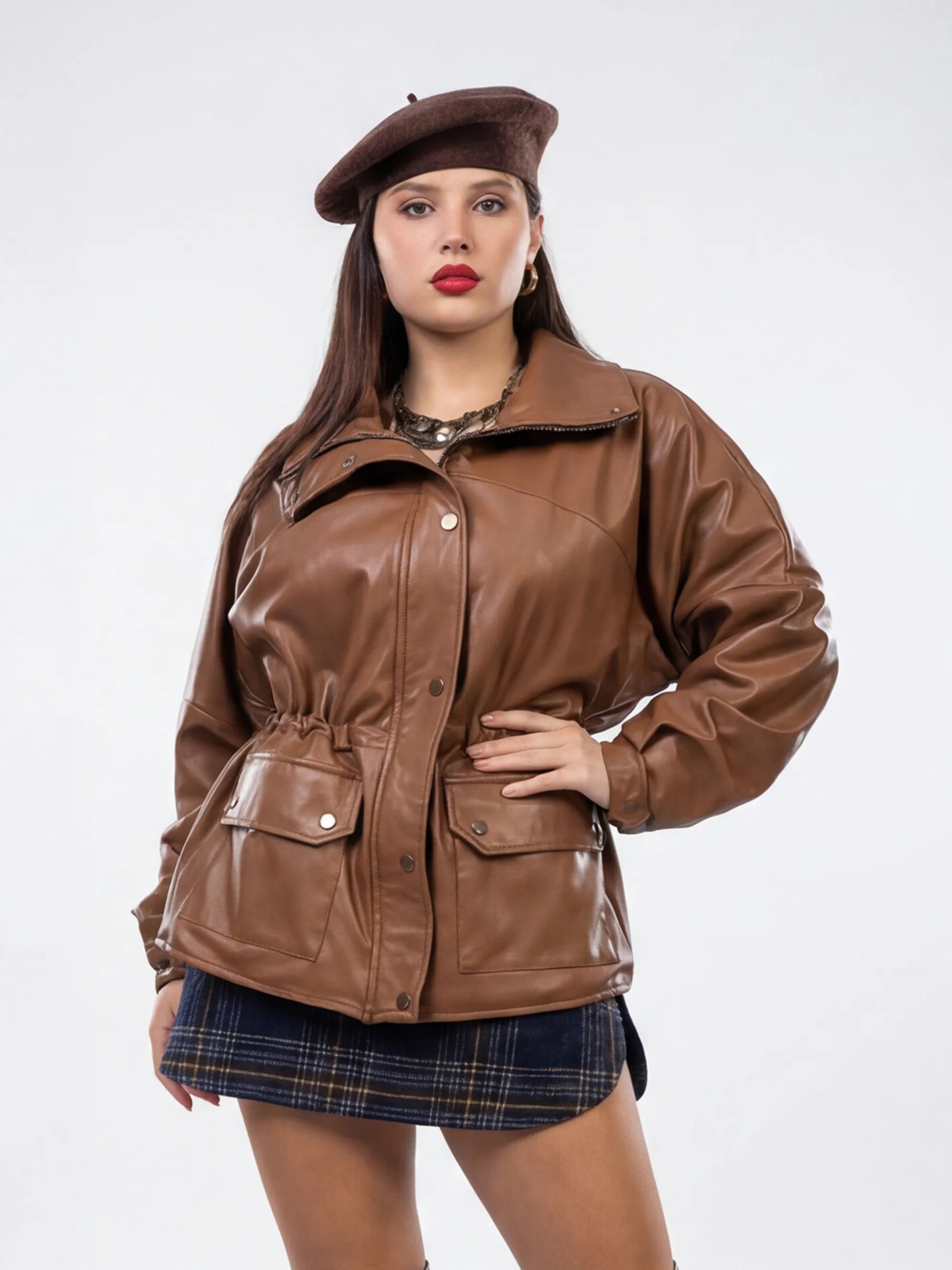 Woman wearing a brown leather jacket and beret on a white background