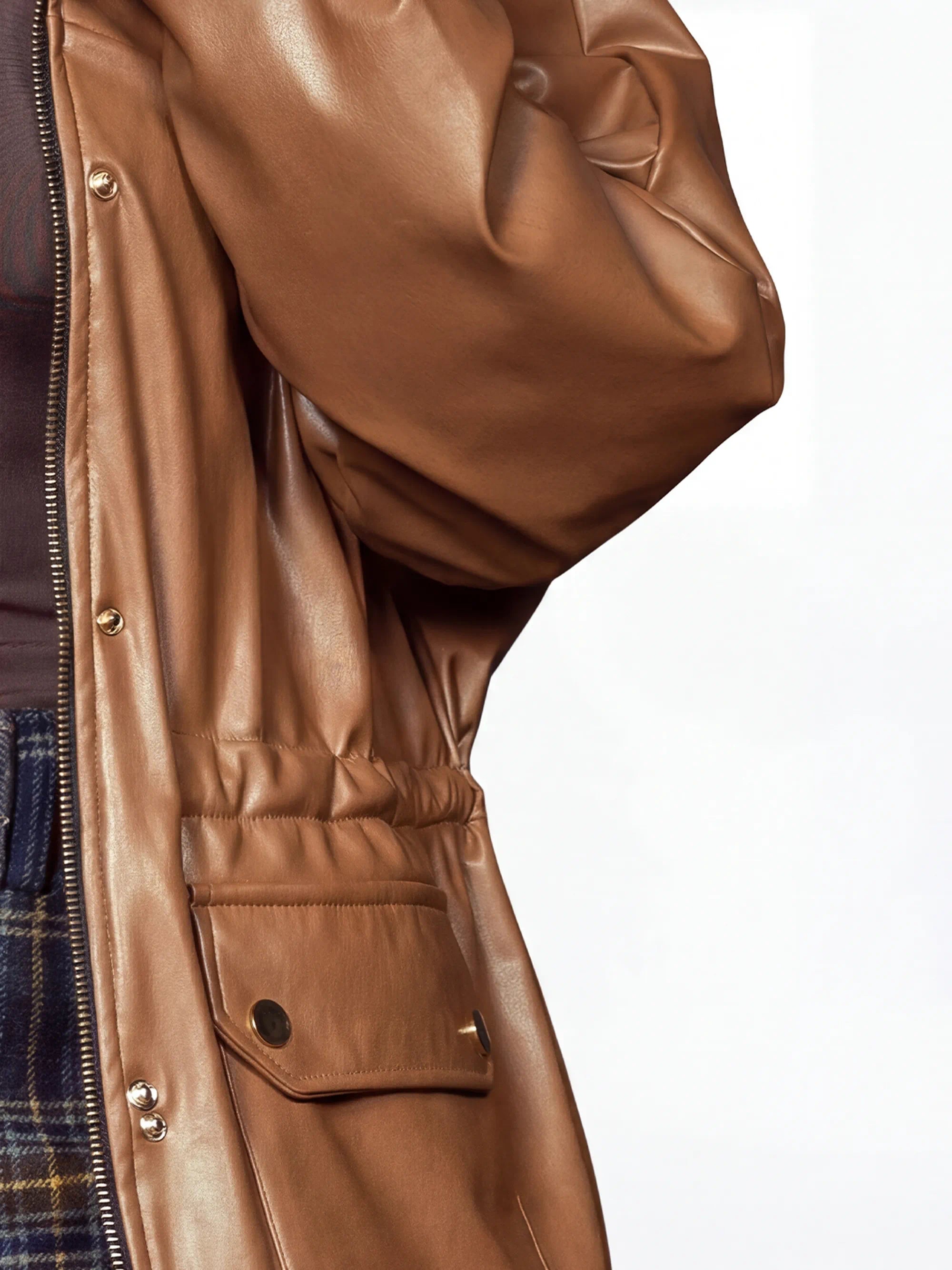 Close-up of a brown leather jacket with a white background