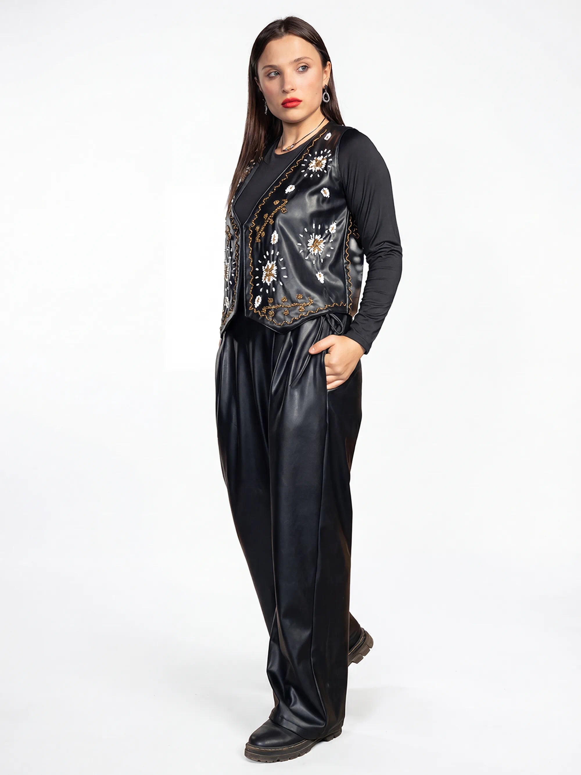 Woman wearing a black outfit with floral embroidery on a white background