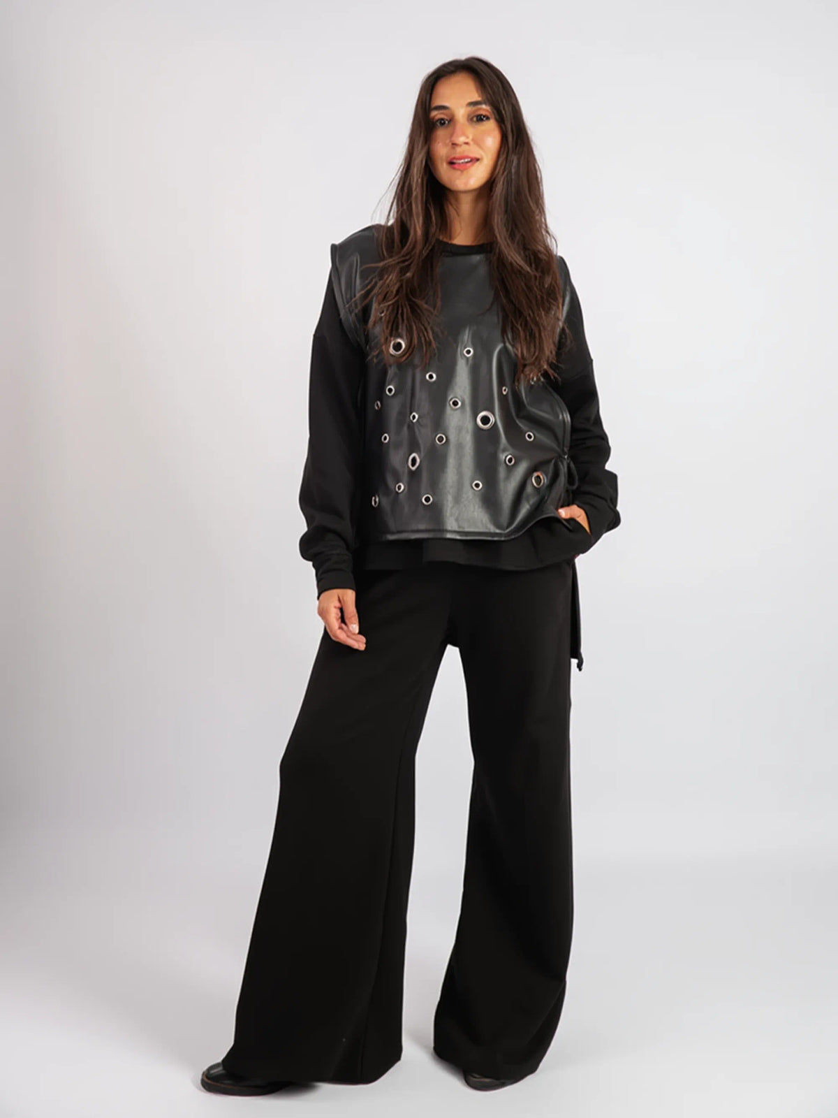 Woman wearing a black outfit with a unique top on a white background
